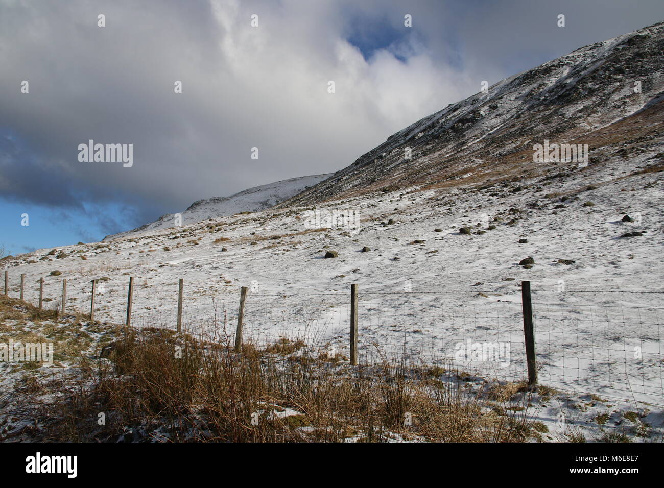 Clouds gather over snow covered deserted hills outside Grasmere in the English Lake District Stock Photo