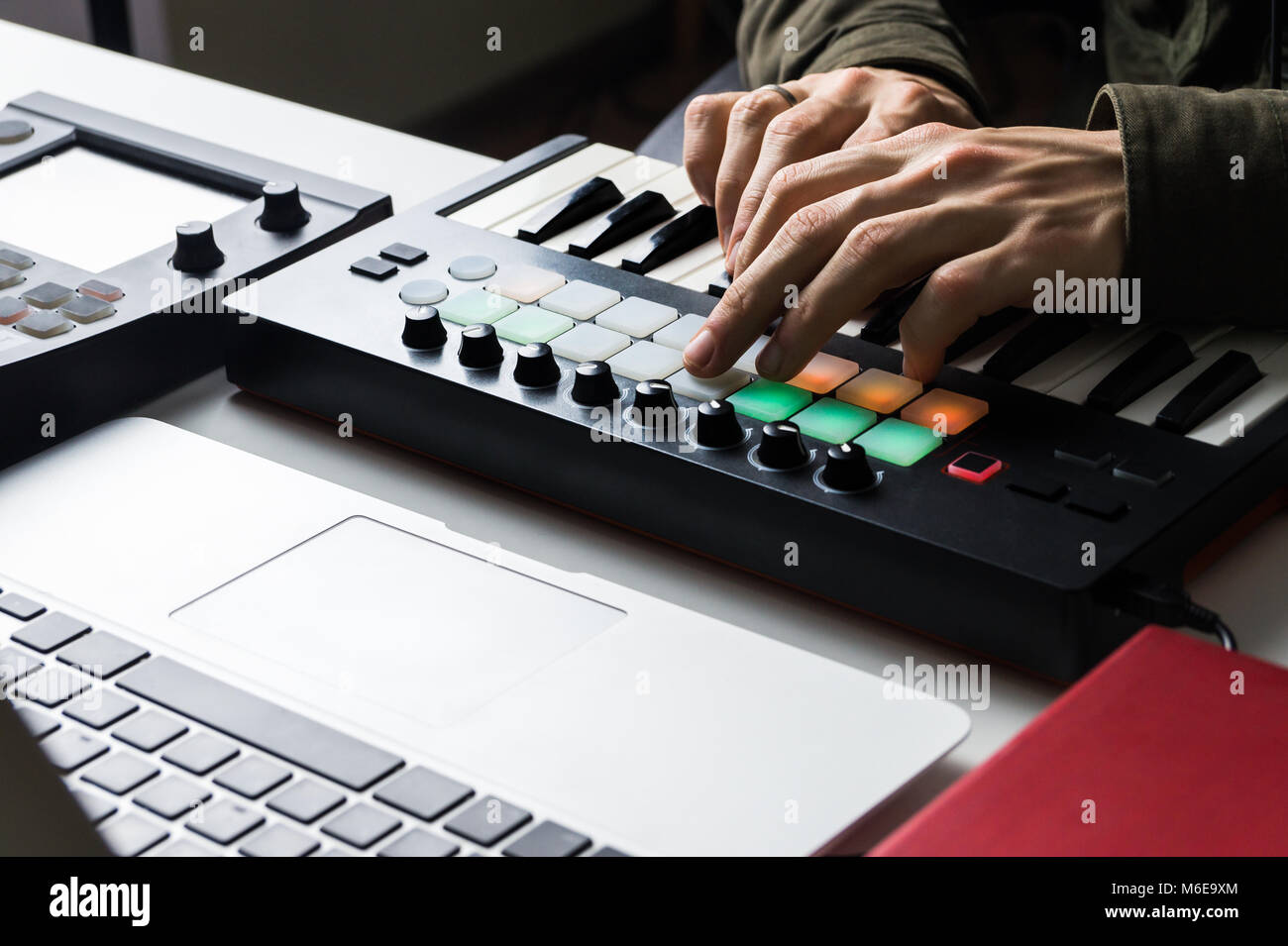 Recording electronic music track with portable midi keyboard on laptop computer in home studio Stock Photo