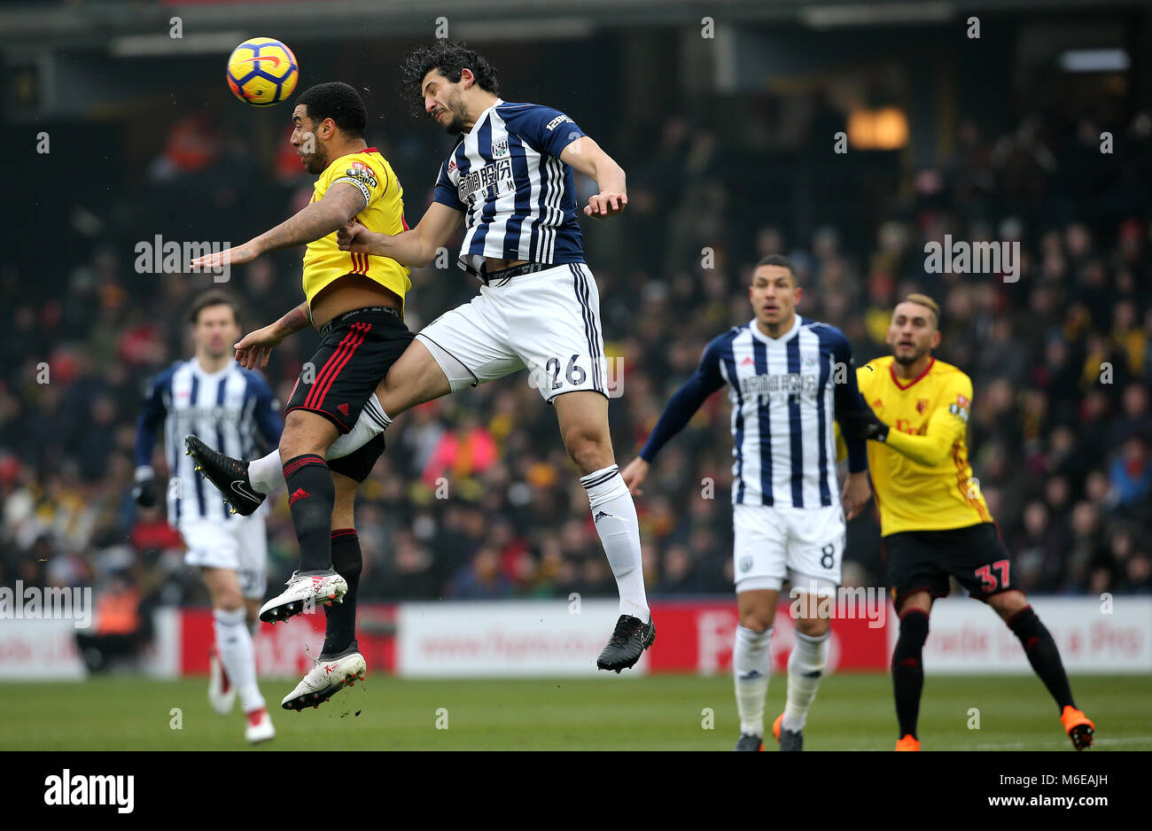West Bromwich Albion's Ahmed Hegazy (right) wins a header against Watford's Troy Deeney during the Premier League match at Vicarage Road, Watford. Stock Photo