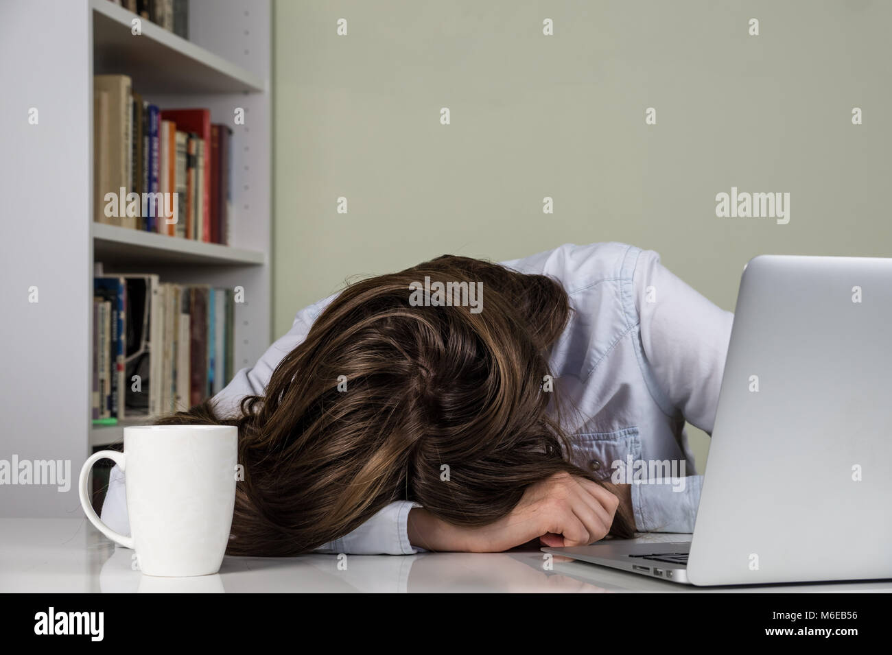 Tired Girl Sleeping At Desk In Front Of Laptop Computer And Tablet