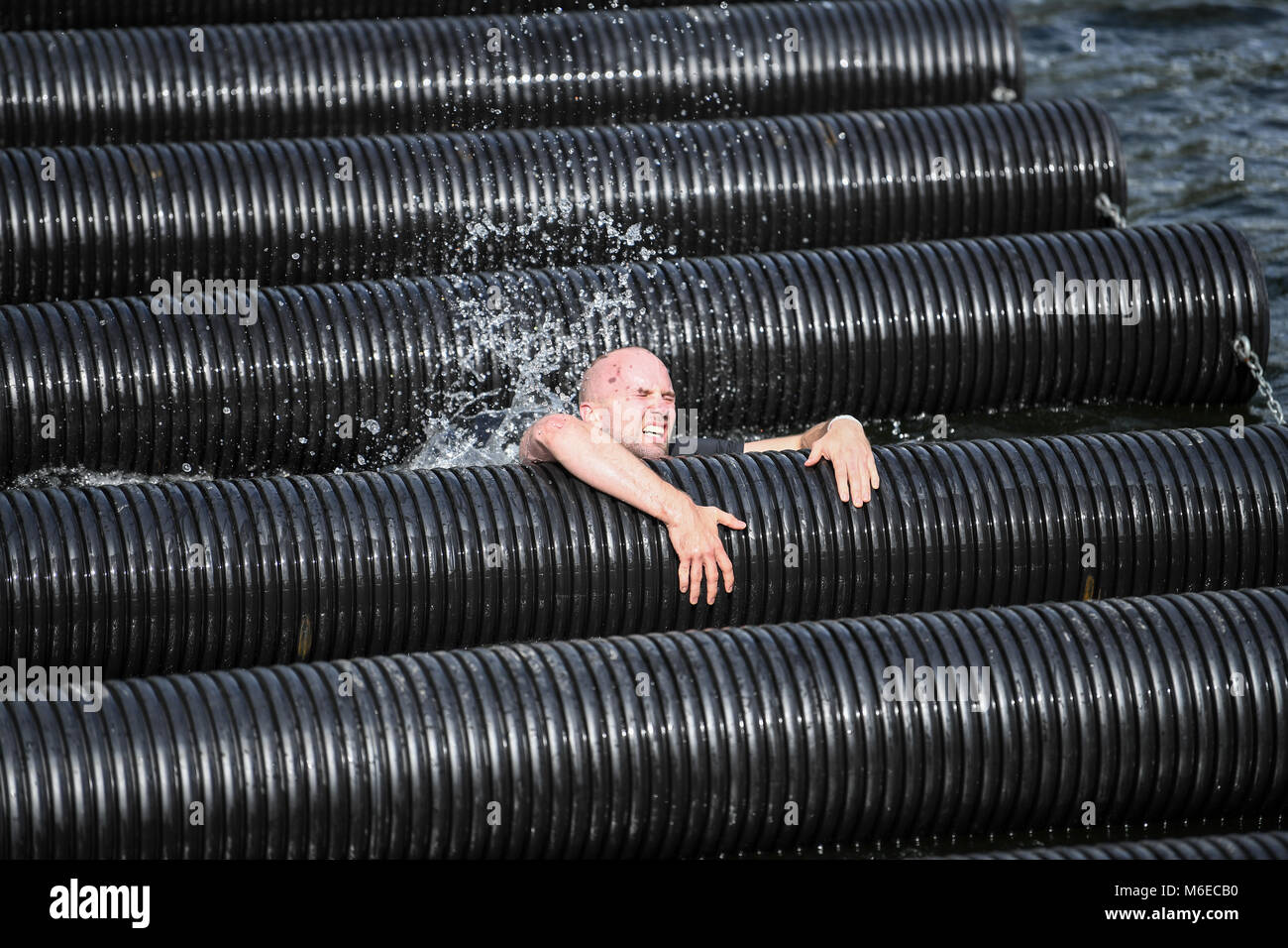 Participant crossing a water obstacle during Action run 2017 obstacle race run in the city of Norrköping, Sweden in September 2017 Stock Photo