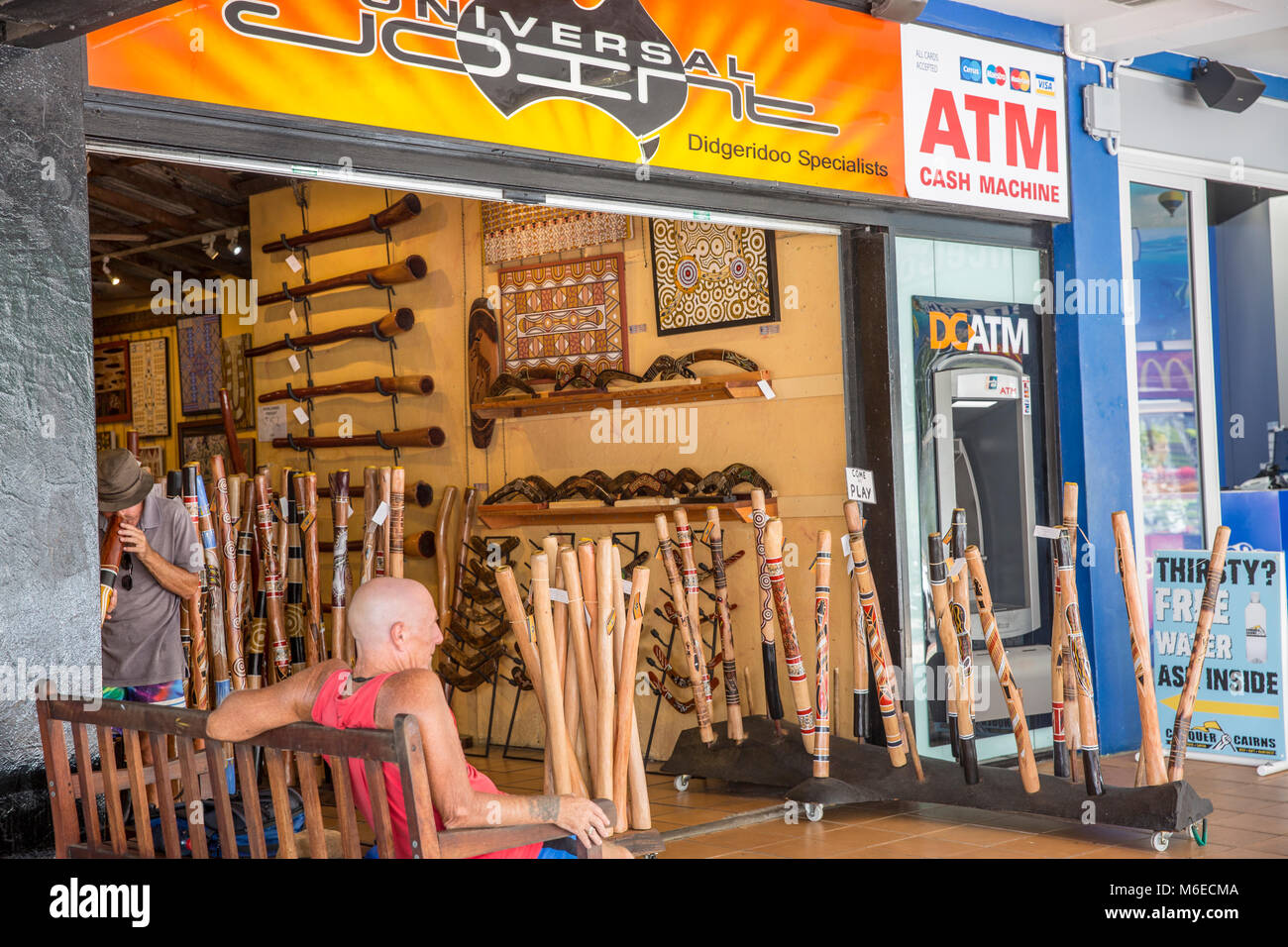 Man playing a didgeridoo musical instrument in a store in Cairns city