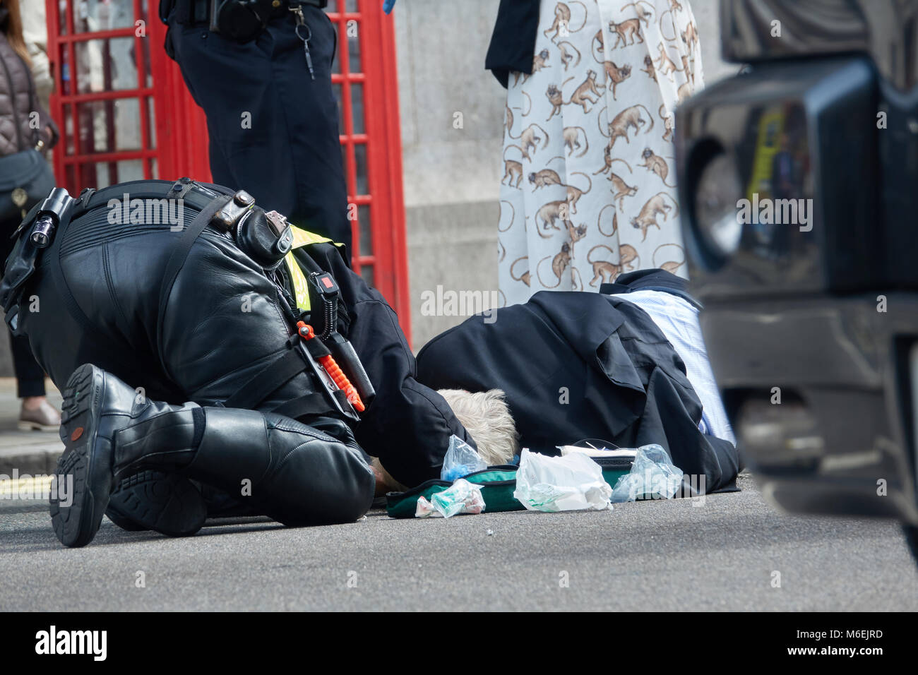 The policeman of London saves the life of an elderly man who was hit by a motorcycle. Stock Photo