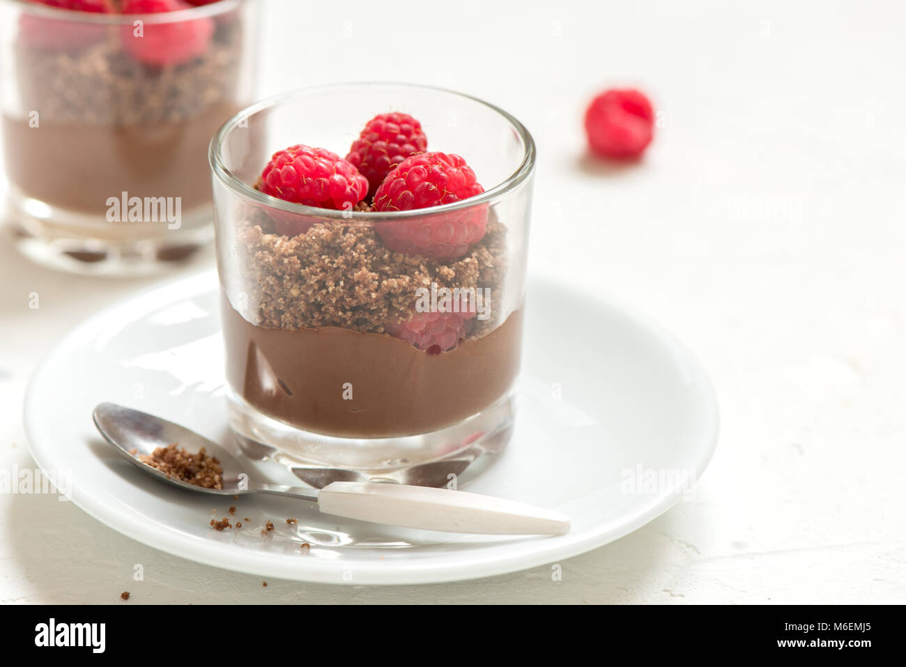 Chocolate dessert in glasses with raspberries. Chocolate mousse or