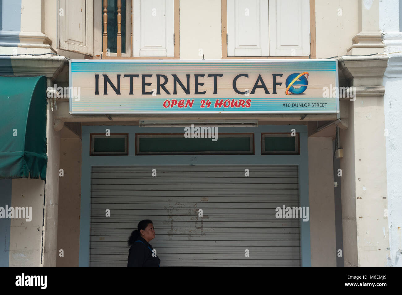 31.01.2018, Singapore, Republic of Singapore, Asia - A woman walks by a closed internet cafe in Singapore's Little India district. Stock Photo