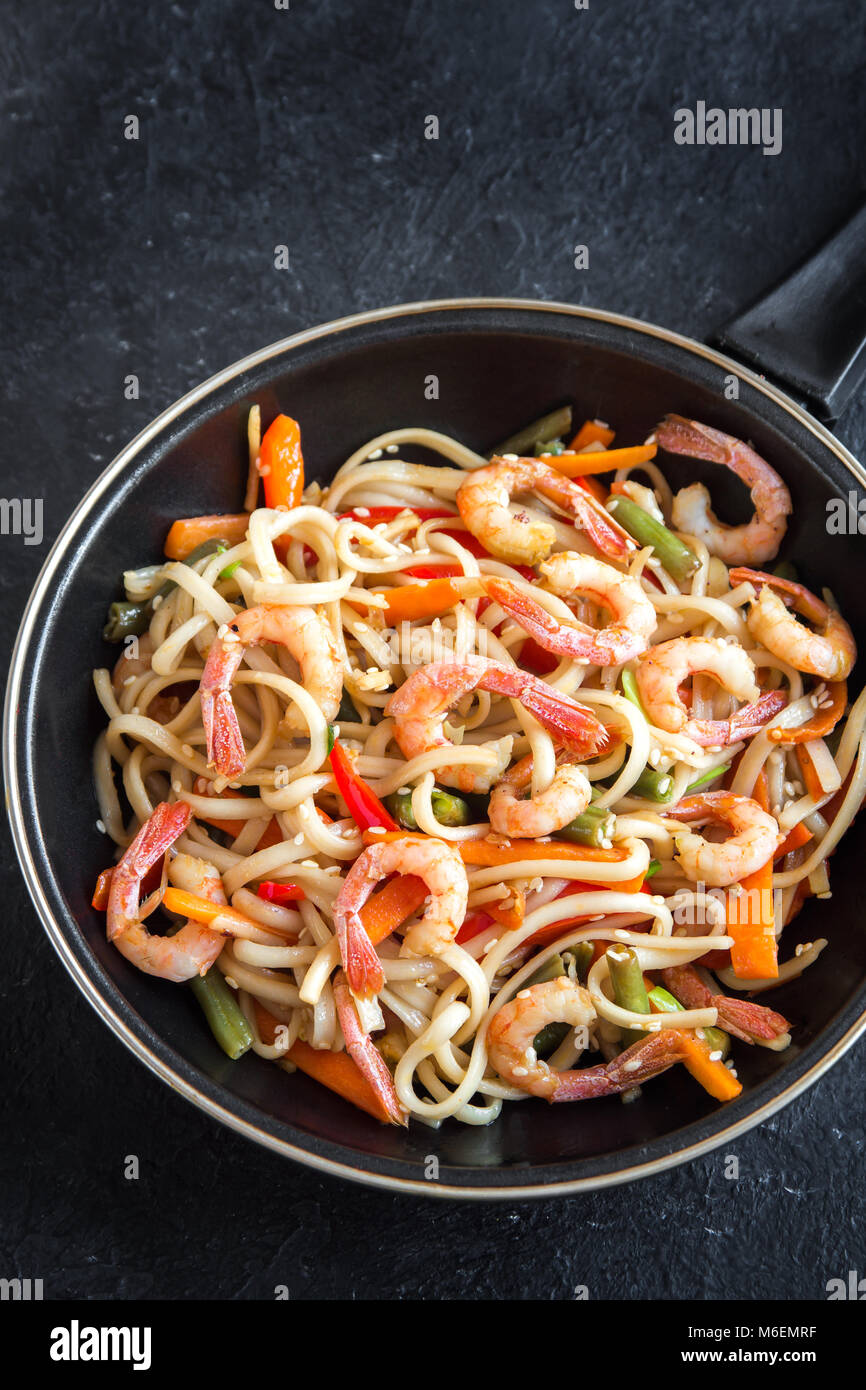 Stir fry with udon noodles, shrimps (prawns) and vegetables. Asian