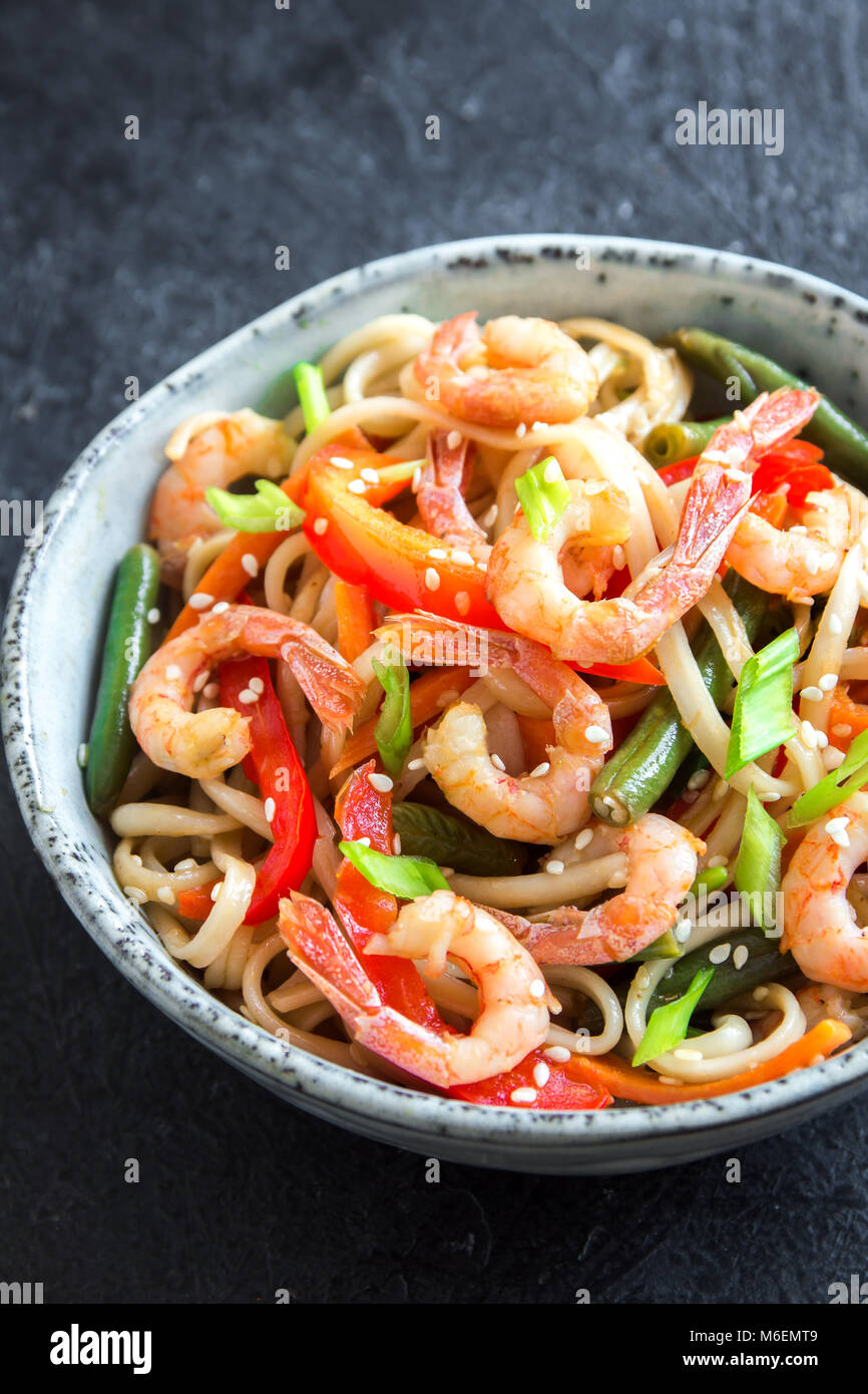 Stir fry with udon noodles, shrimps (prawns) and vegetables. Asian