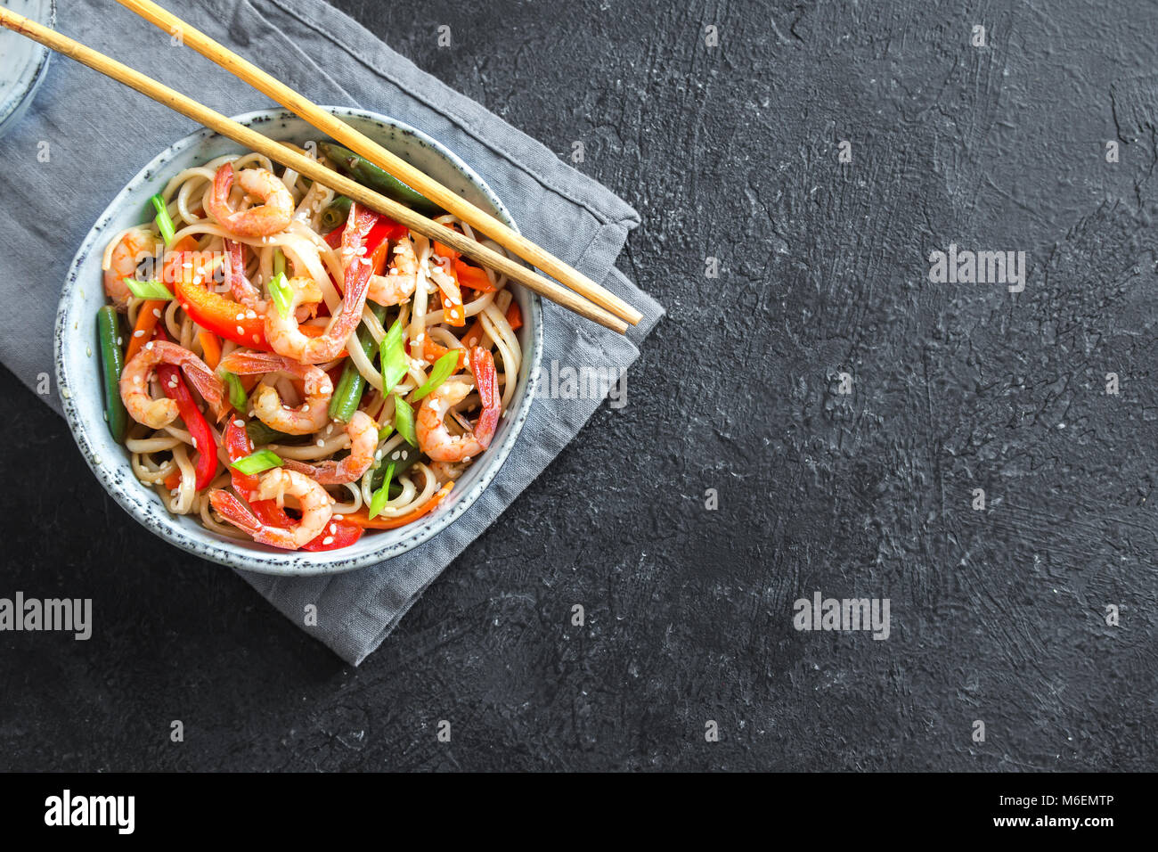 Stir fry with udon noodles, shrimps (prawns) and vegetables. Asian