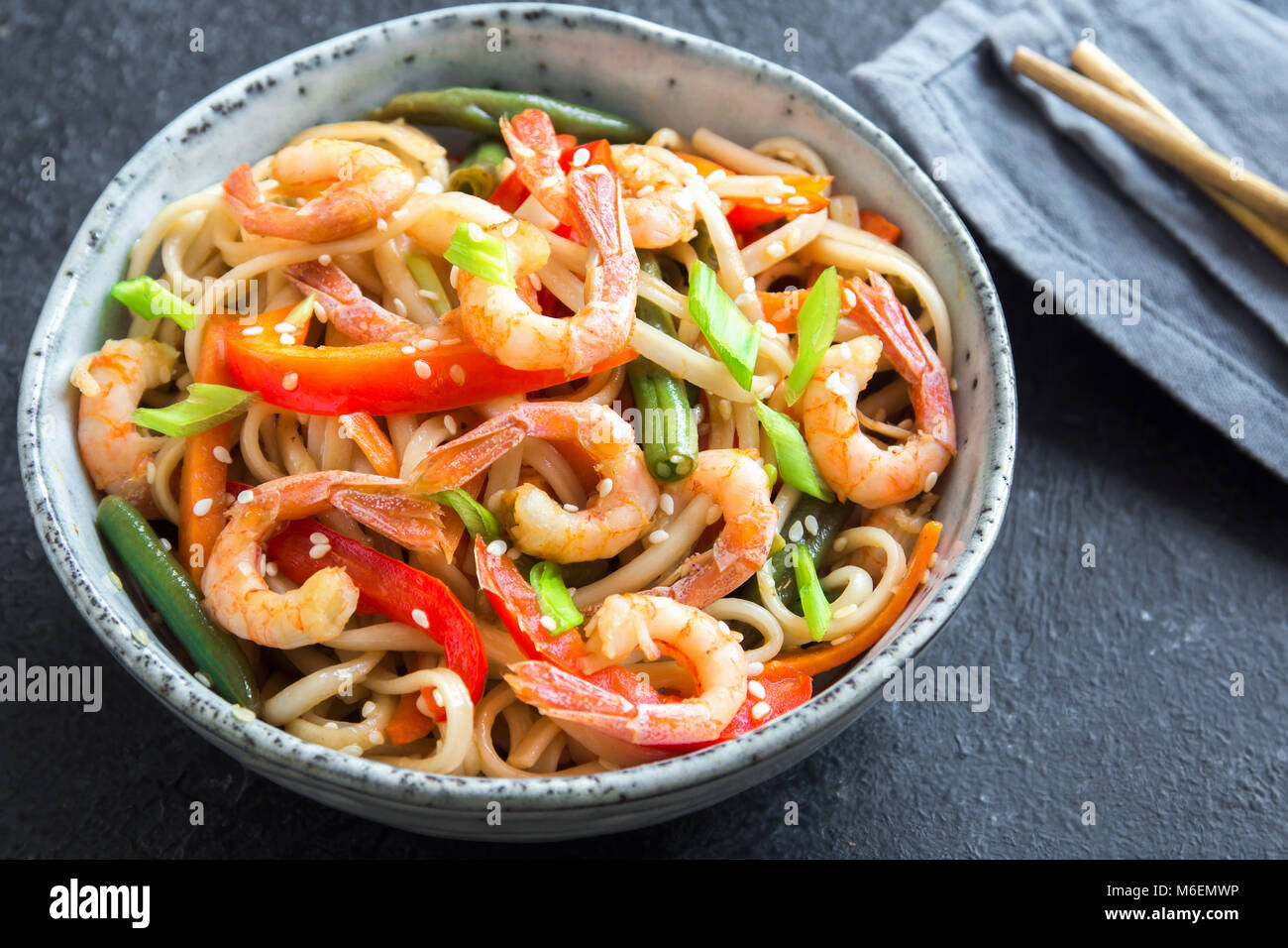 Stir fry with udon noodles, shrimps (prawns) and vegetables. Asian