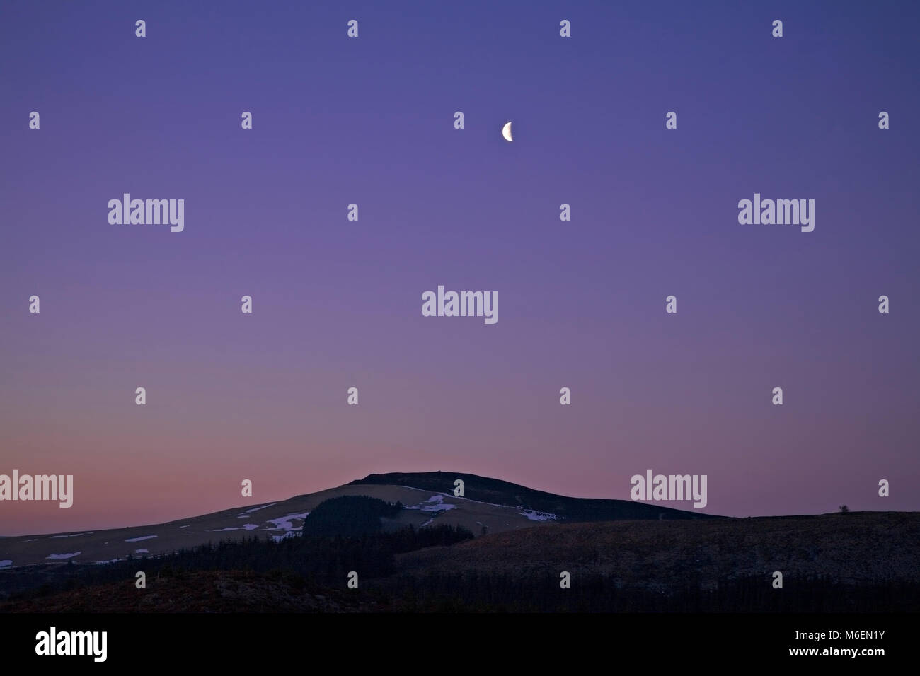 Crescent moon over Moel Famau at dawn, Clwydians, Wales Stock Photo