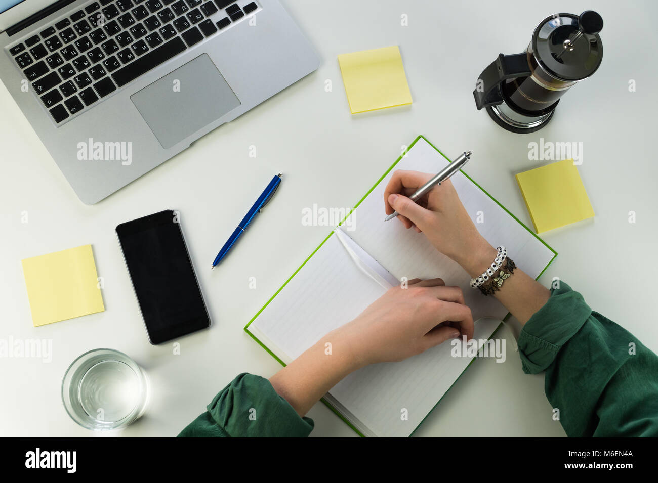 Writing in notepad at desk with smartphone and laptop computer Stock ...