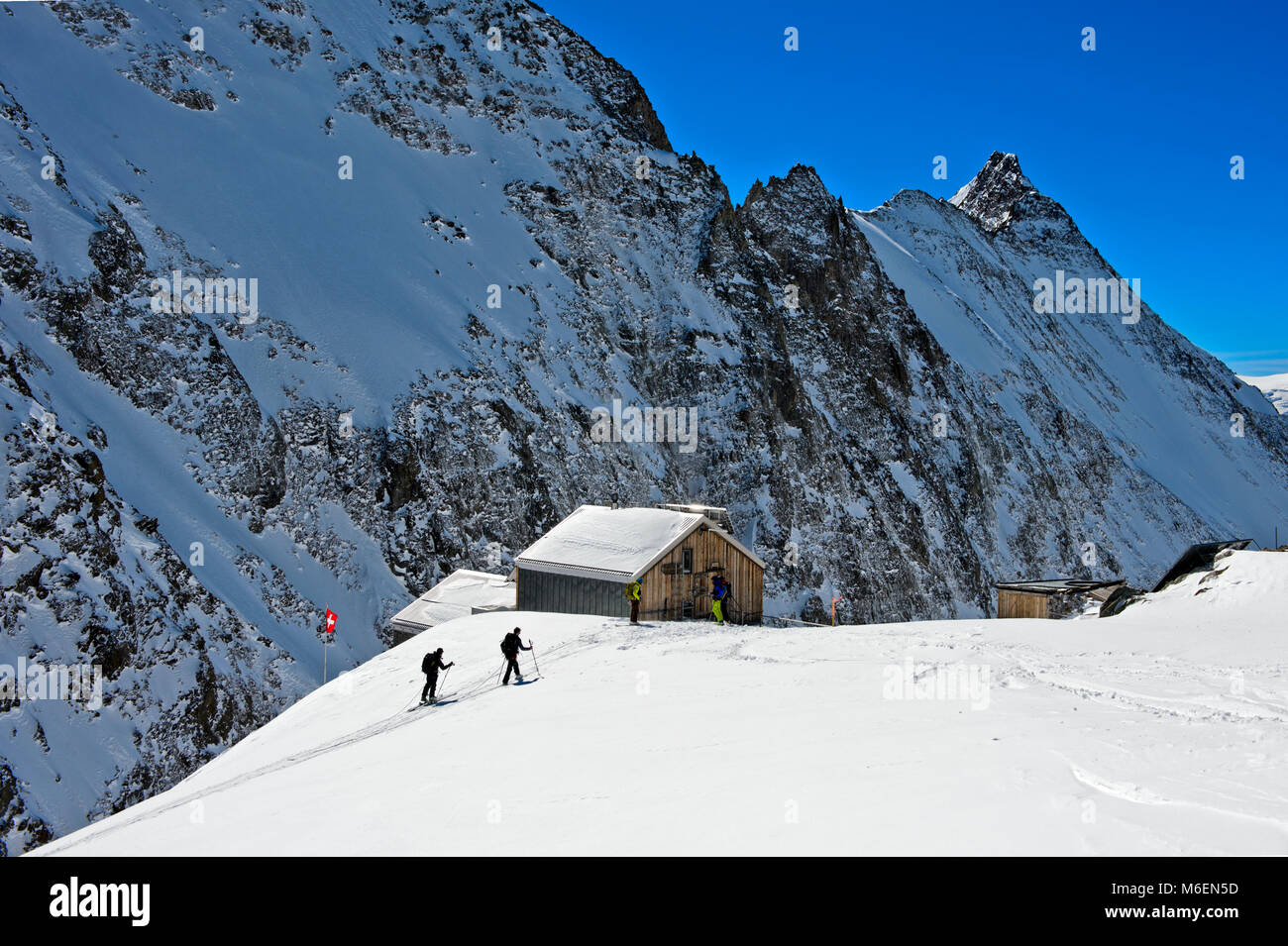 Ski tourers ariving at the mountain refuge Hollandiahütte on the Loetschenluecke pass, Blatten, Loetschental, Valais, Switzerland Stock Photo