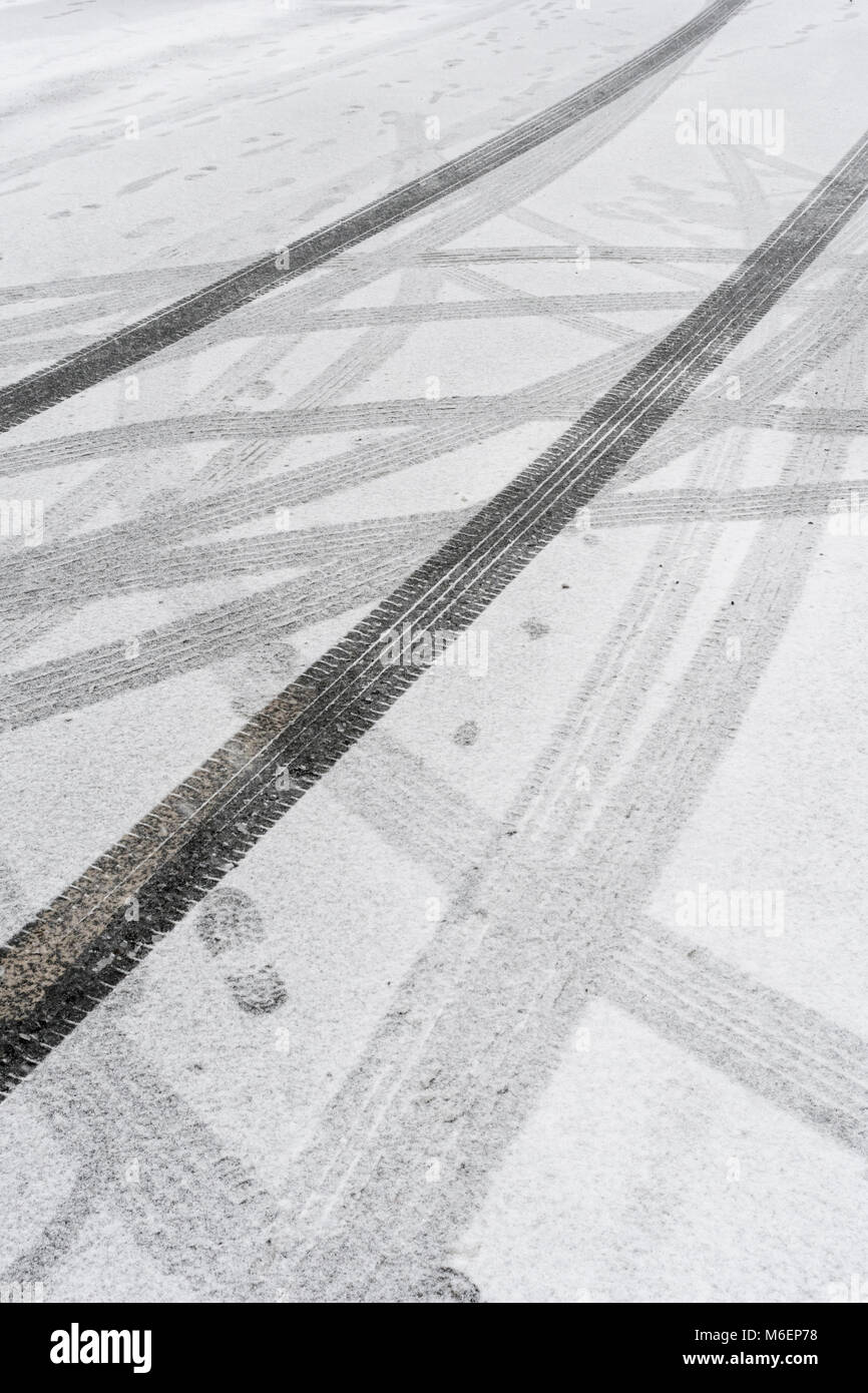 Car tyre tracks marks in snow during the 2018 Beast from the East polar vortex snows which caused widespread problems for commuters and travel. Stock Photo