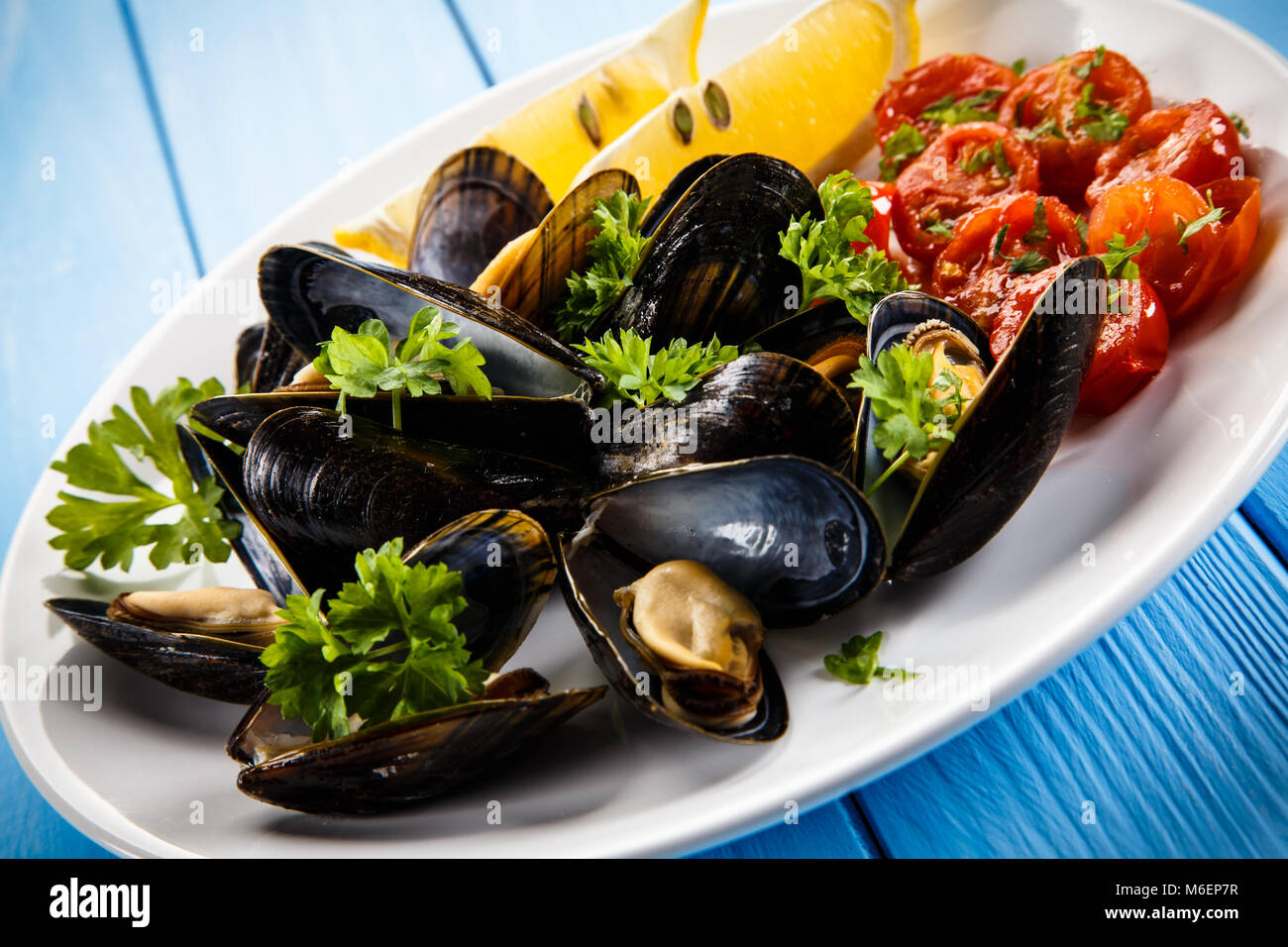 Cooked mussels with lemon and cherry tomatoes Stock Photo Alamy