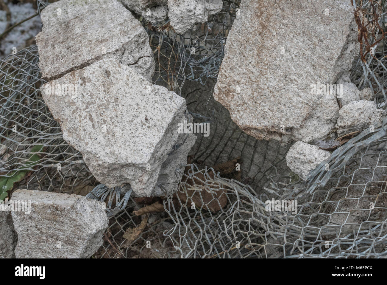 Close-up of mesh and concrete at a builder's rubble pile. Metaphor for broken in pieces, in tatters, shattered in pieces. Stock Photo