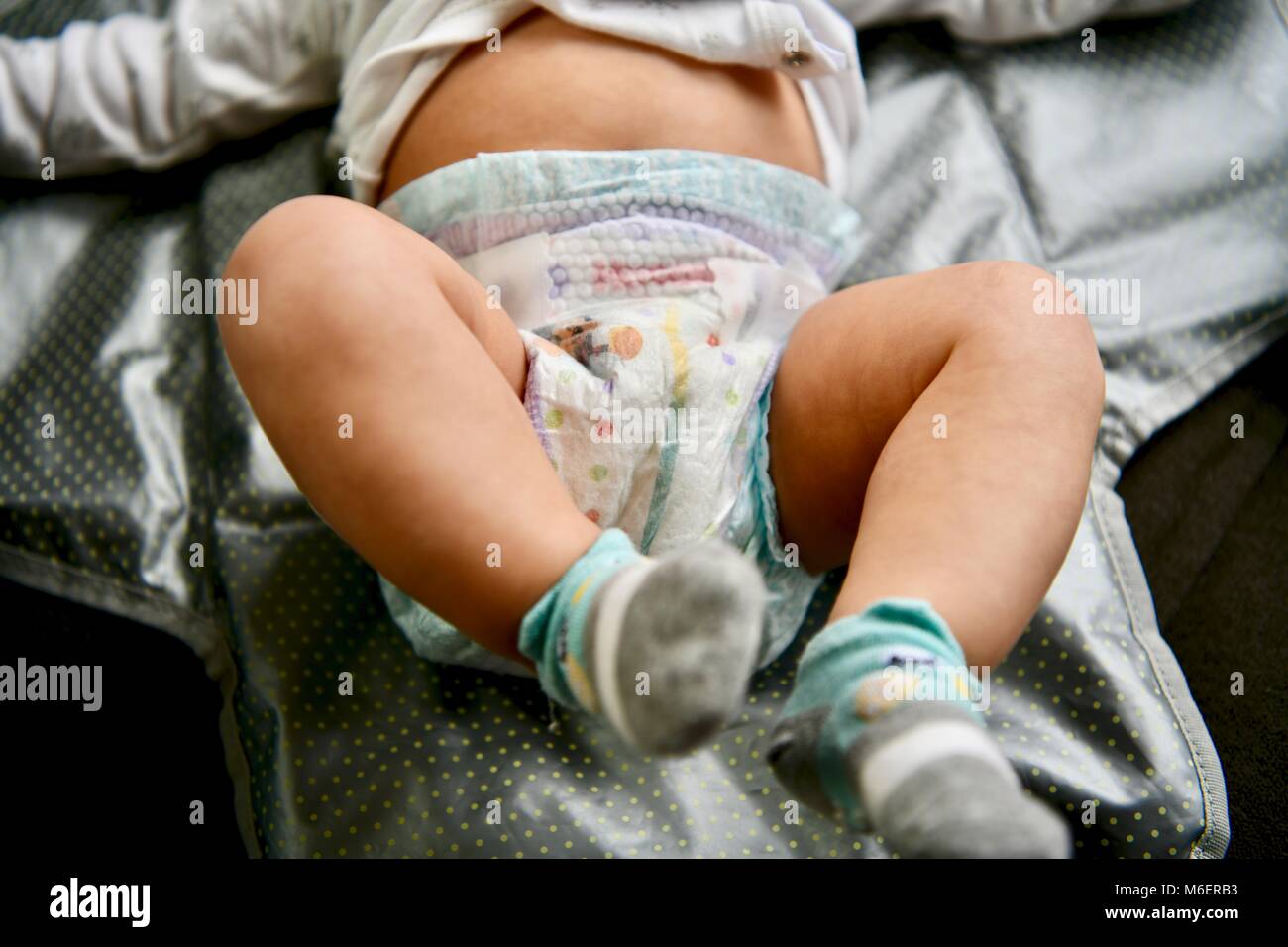Infant wearing Huggies baby diaper with yellow line turning blue to