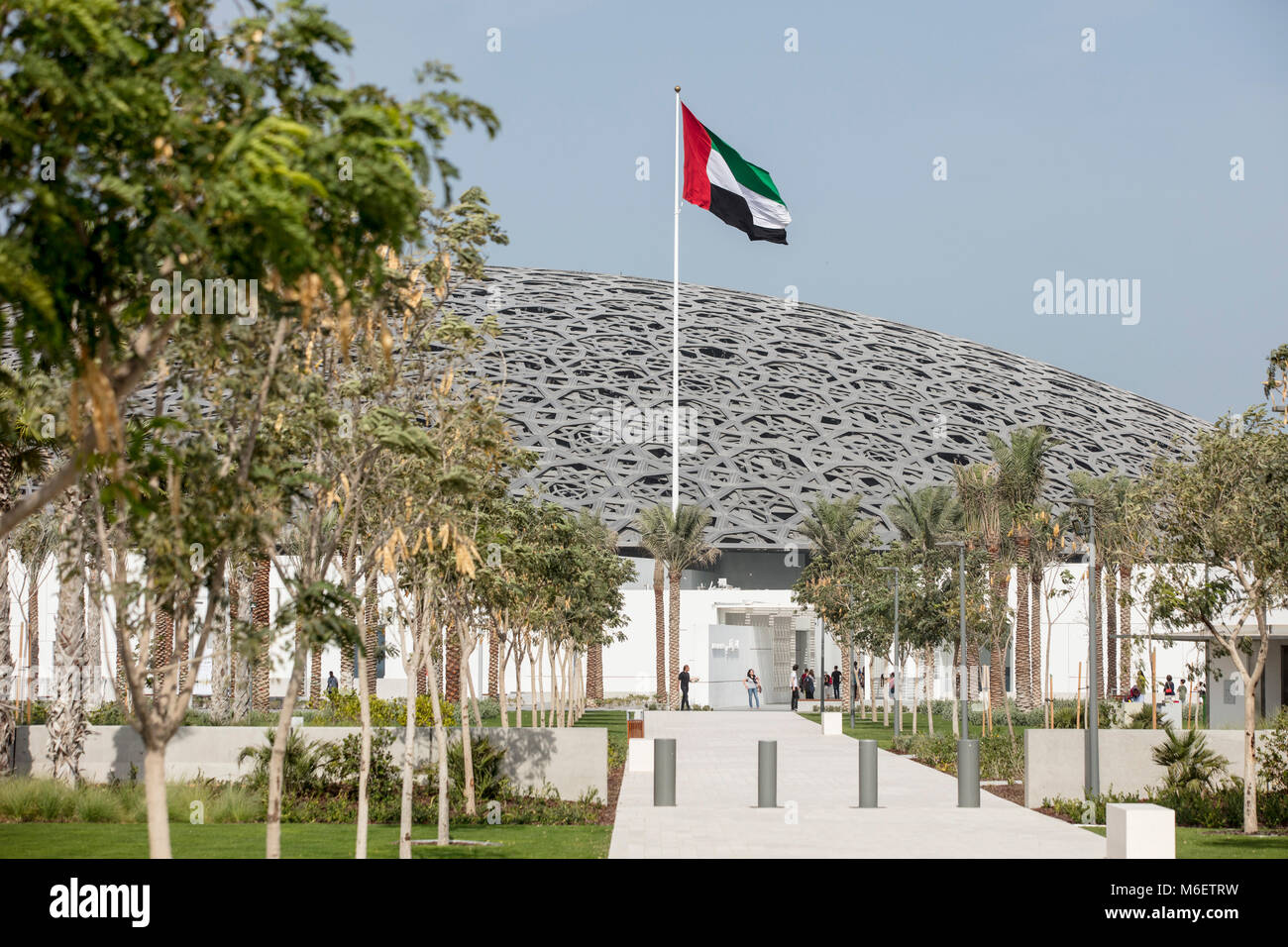 ABU DHABI, UNITED ARAB EMIRATES -  February 24, 2018: The UAE flag outside of the Louvre Abu Dhabi, designed by architect Jean Nouvel. Stock Photo