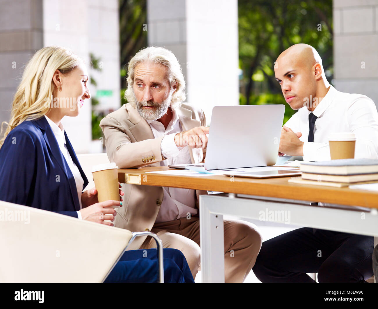 multinational and multiethnic corporate executives business people meeting in lobby of modern office building. Stock Photo