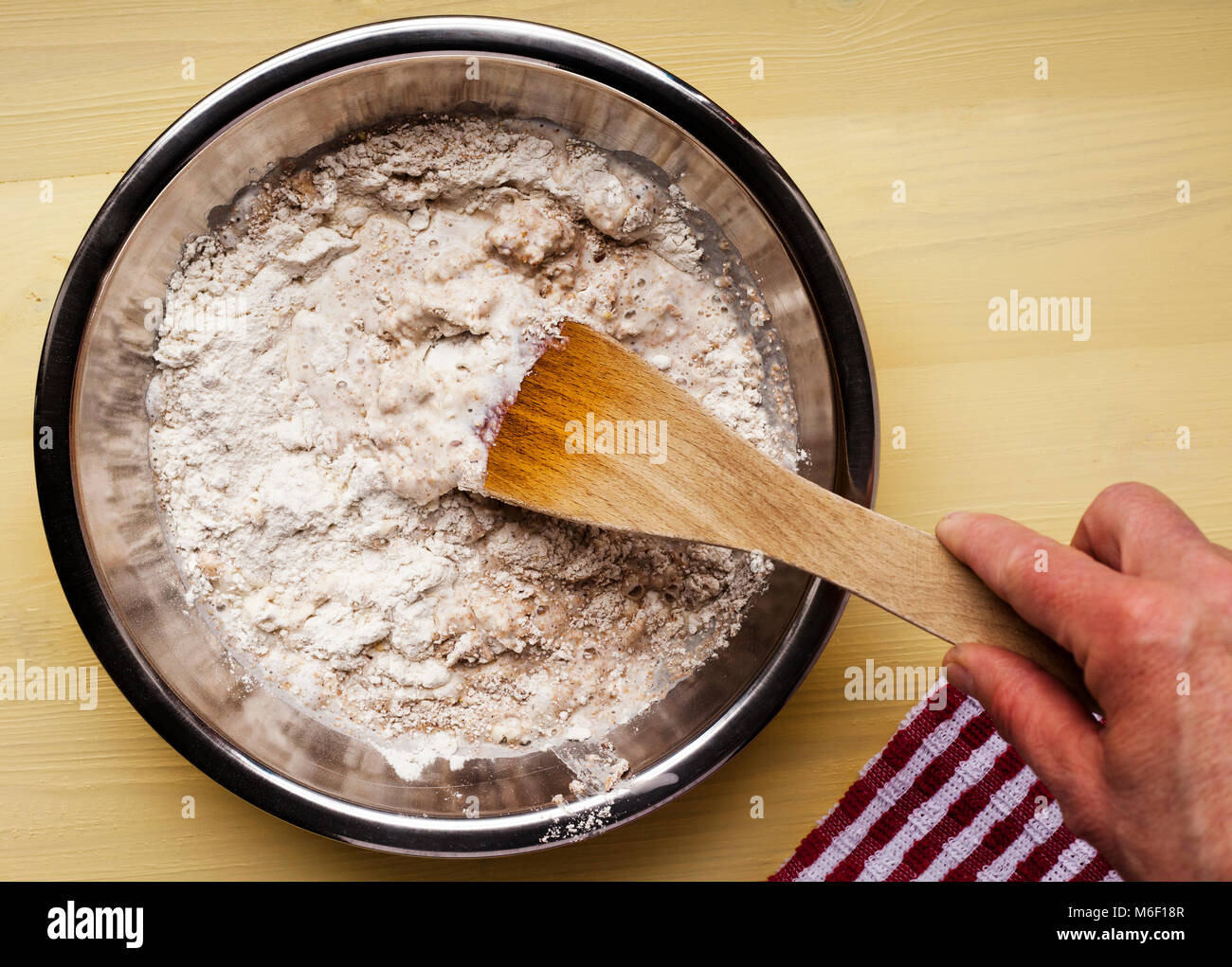 Home baker mixing plain, wholemeal flower with salt and baking powder