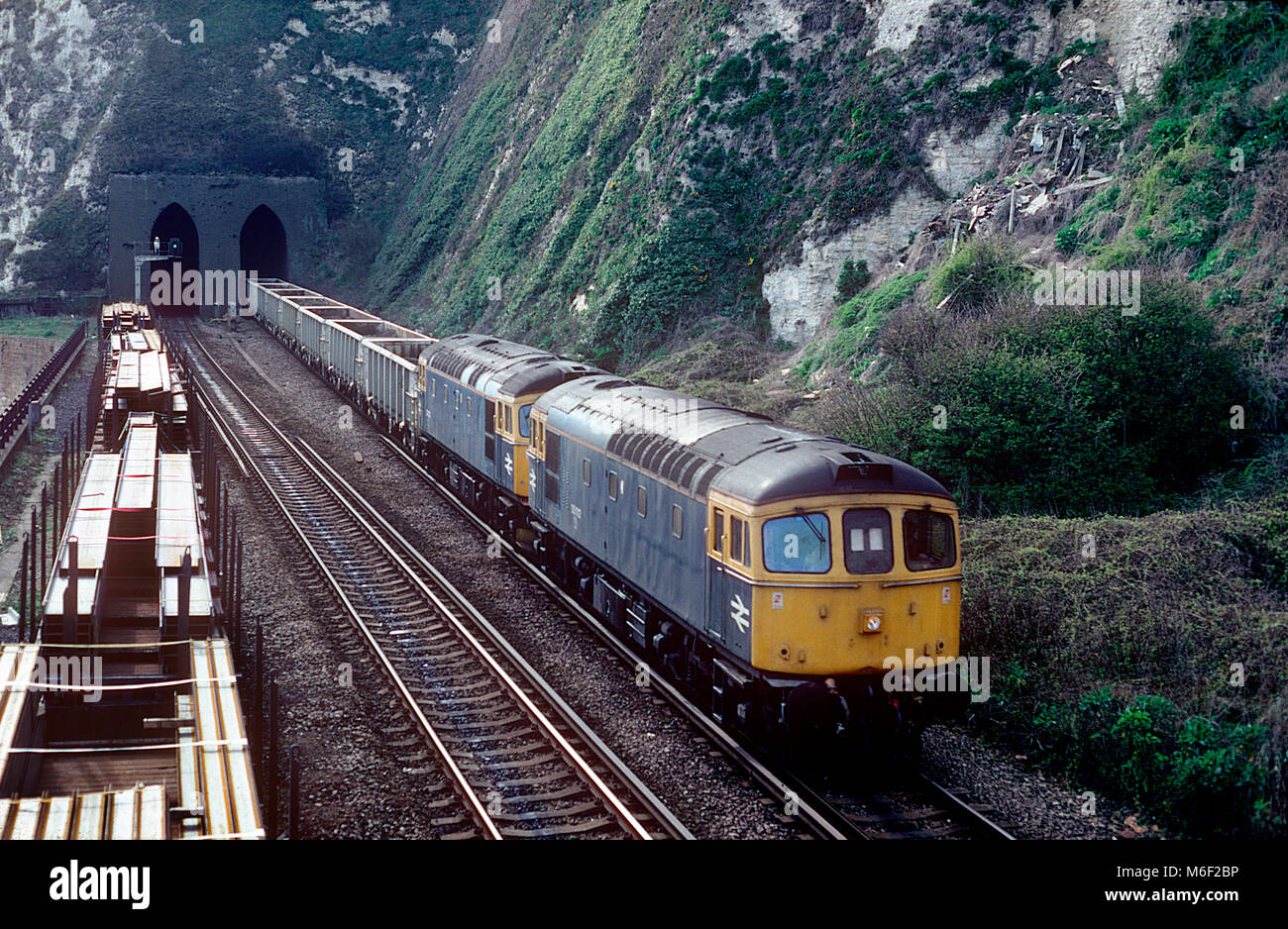 A pair of class 33 diesel locomotives led by 33012 emerge from Shakespeare Cliff tunnel near Dover with a weekend engineers train on the 4th April 1992. Stock Photo
