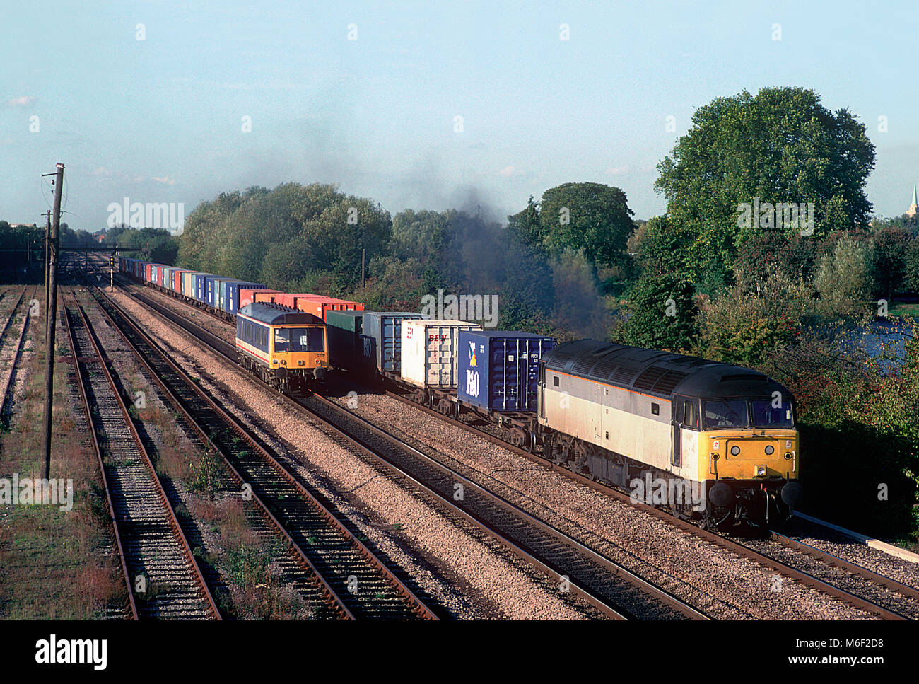 A class 47 diesel locomotive number 47187 heads south with freightliner while a class 121 'bubble car' diesel multiple unit number L128 heads north. Hinksey yard, Oxford. 21st October 1995. Stock Photo