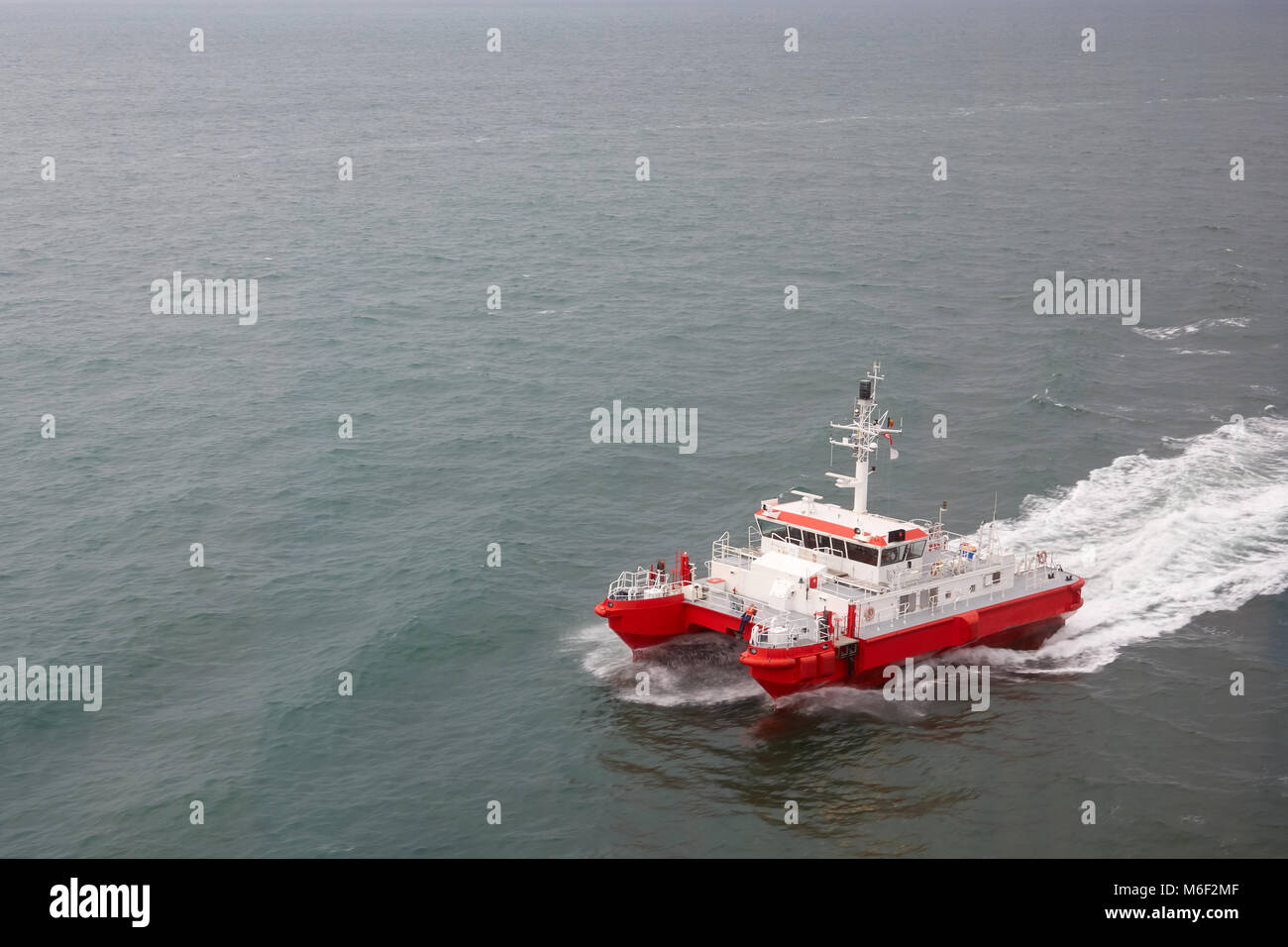 Modern tugboat of red and white color in the sea closeup. Stock Photo