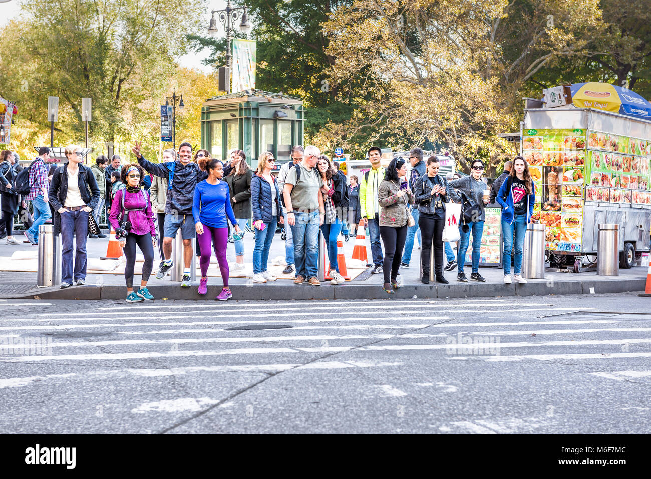 New York City, USA - October 28, 2017: Midtown Manhattan with happy young people crossing street of Columbus Circle from Central Park road in traffic  Stock Photo
