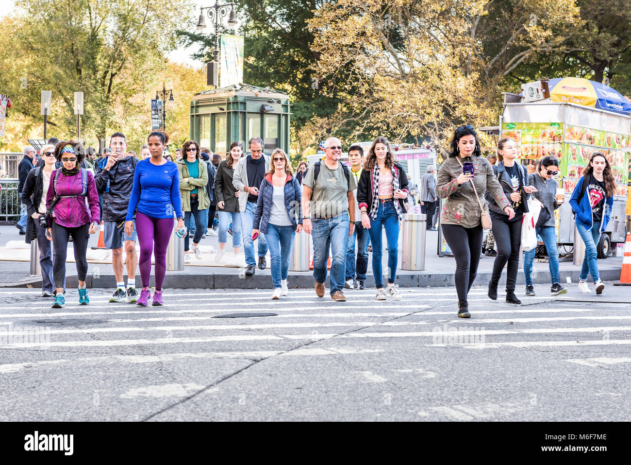 New York City, USA - October 28, 2017: Midtown Manhattan with happy young people crossing street of Columbus Circle from Central Park road in traffic  Stock Photo