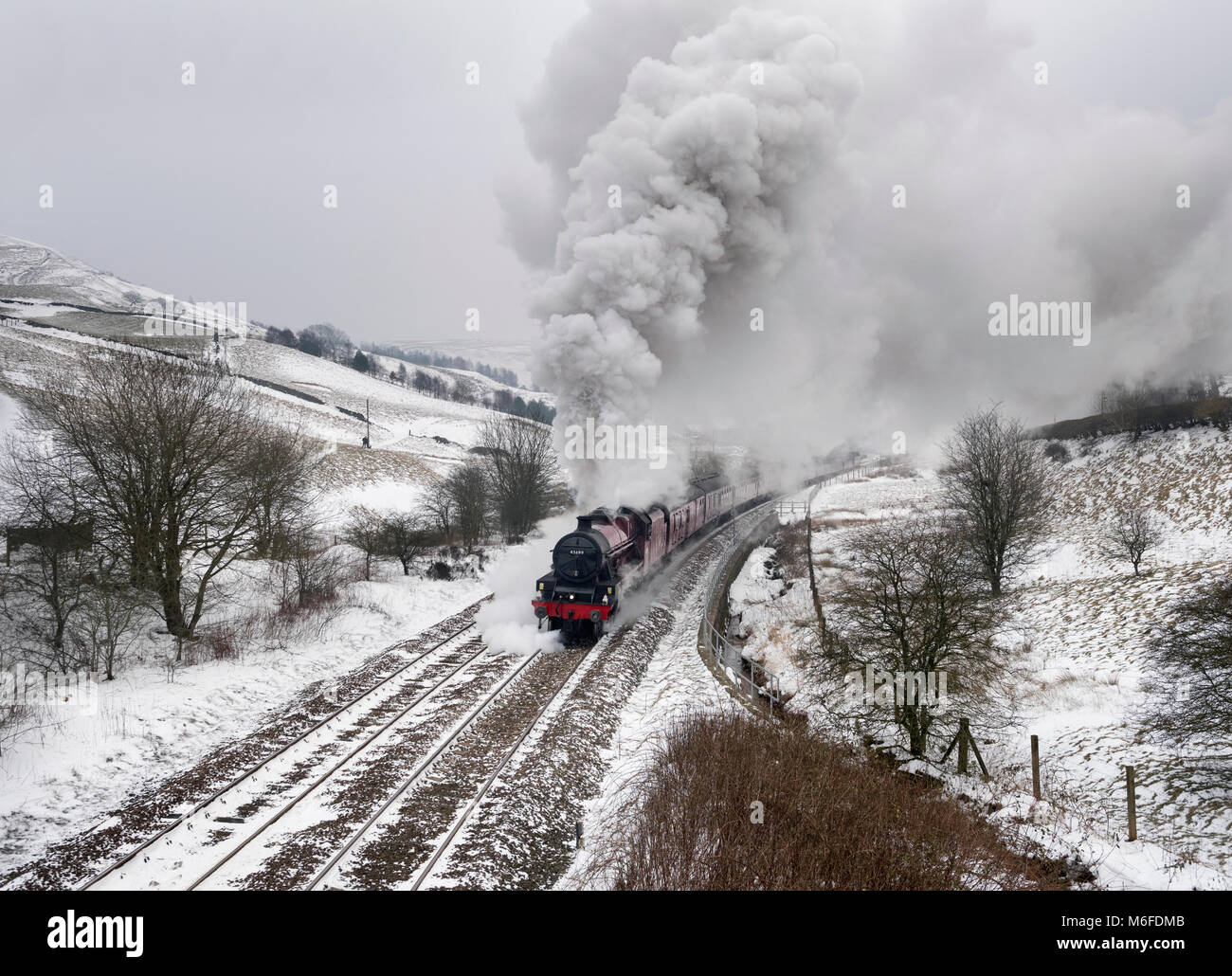 Lancashire, UK. 3rd March 2018. In a Wintery landscape, steam locomotive 'Galatea' hauls 'The Pennine Limited' special train up Copy Pit incline, near Burnley, Lancashire. The combination of cold weather and the steep gradient produce an impressive amount of smoke and steam from the locomotive. The trip went from Carnforth (Lancashire) to Preston, Manchester, Sheffield, Wakefield, and Blackburn before returning to Carnforth. Credit: John Bentley/Alamy Live News Stock Photo