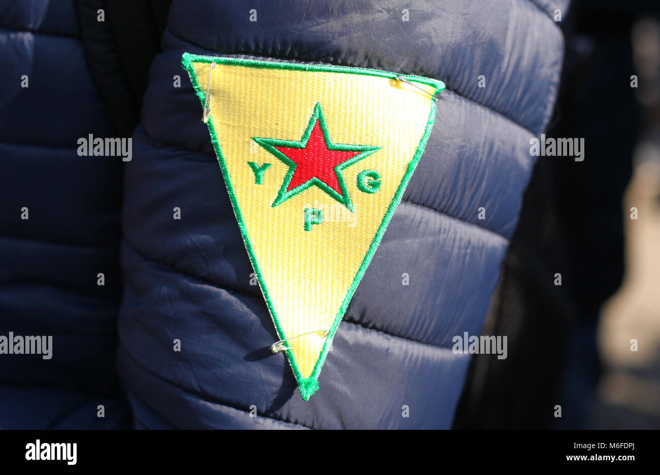 Berlin, Germany. 3rd March 2018. A protestor wears a patch of the armed ...