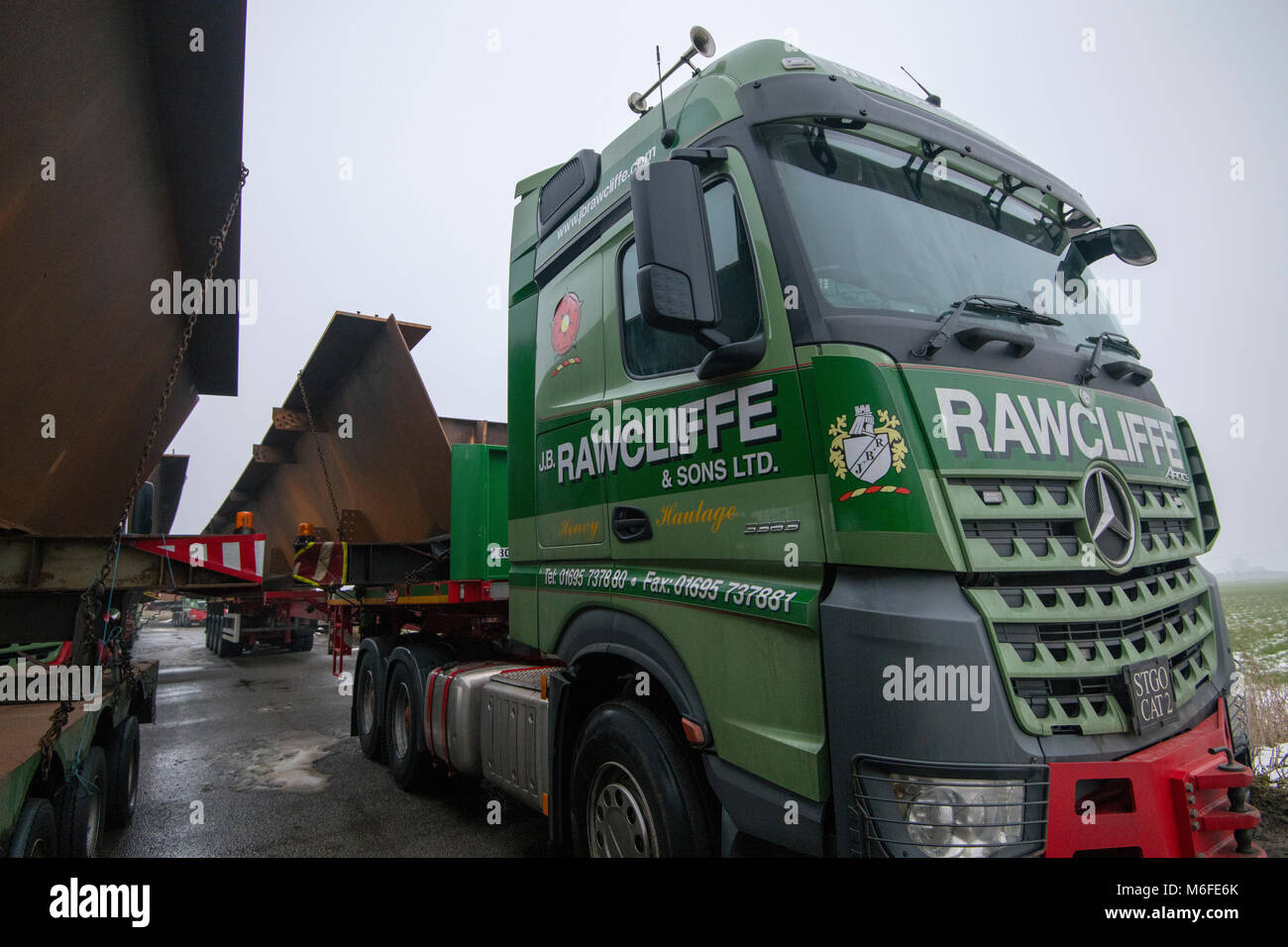 Heavy haulage trucks carrying metal for bridge construction for the