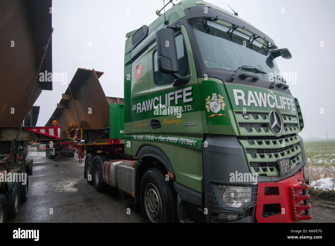 Heavy haulage trucks carrying metal for bridge construction for the