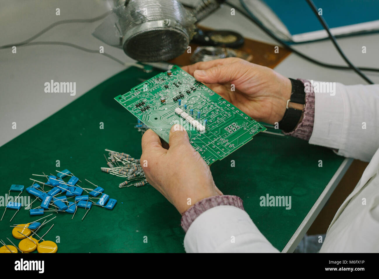 Female computer expert professional technician examining board computer in a laboratory in a factory. Stock Photo
