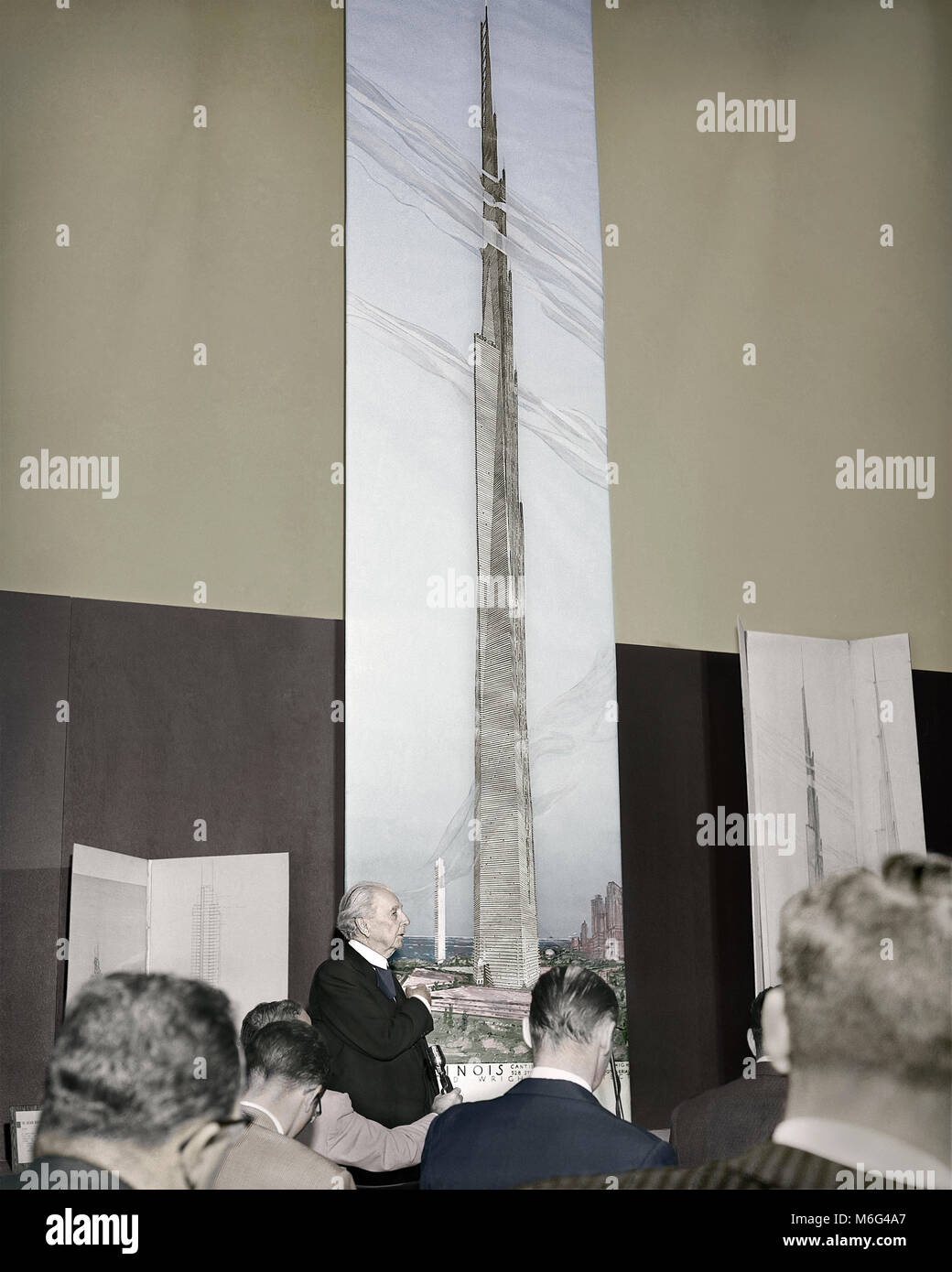 Frank Lloyd Wright unveils a 22-foot-high drawing of the mile-high building he proposes for Chicago. October 16, 1956. Image colorized from original camera negative. Stock Photo