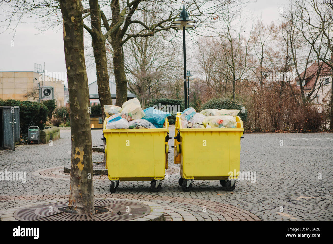 Two yellow garbage containers on a street in Germany. Collection and