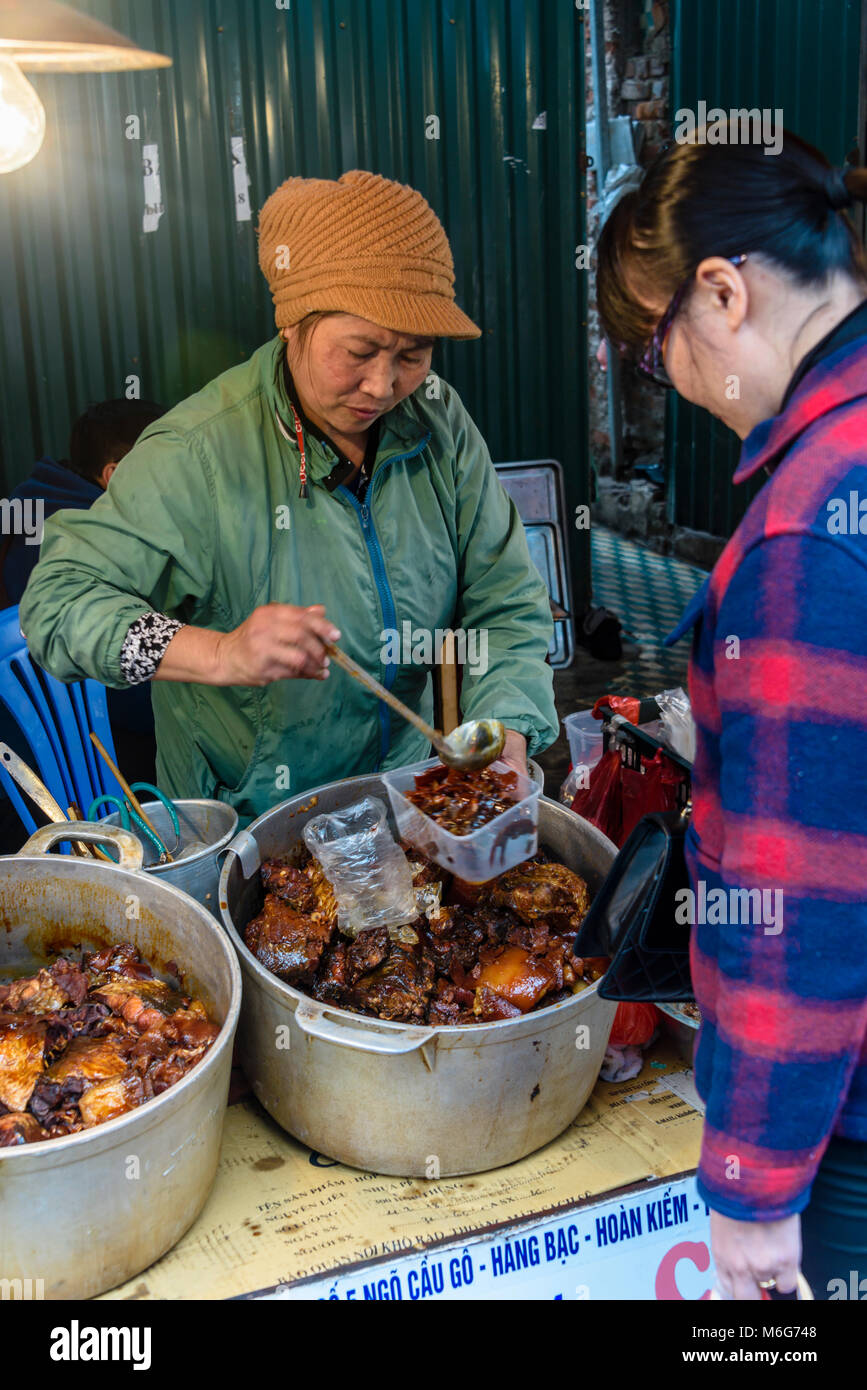A woman sells traditional Vietnamese street food in Hanoi, Vietnam Stock Photo