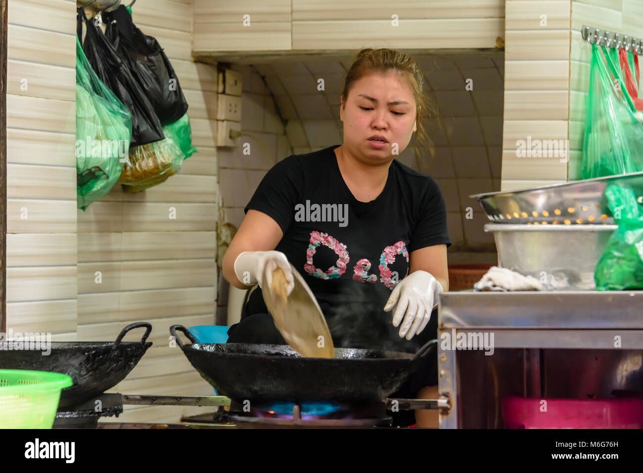 A woman fries food in a wok, in the kitchen of a restaurant in Hanoi,  Vietnam Stock Photo - Alamy