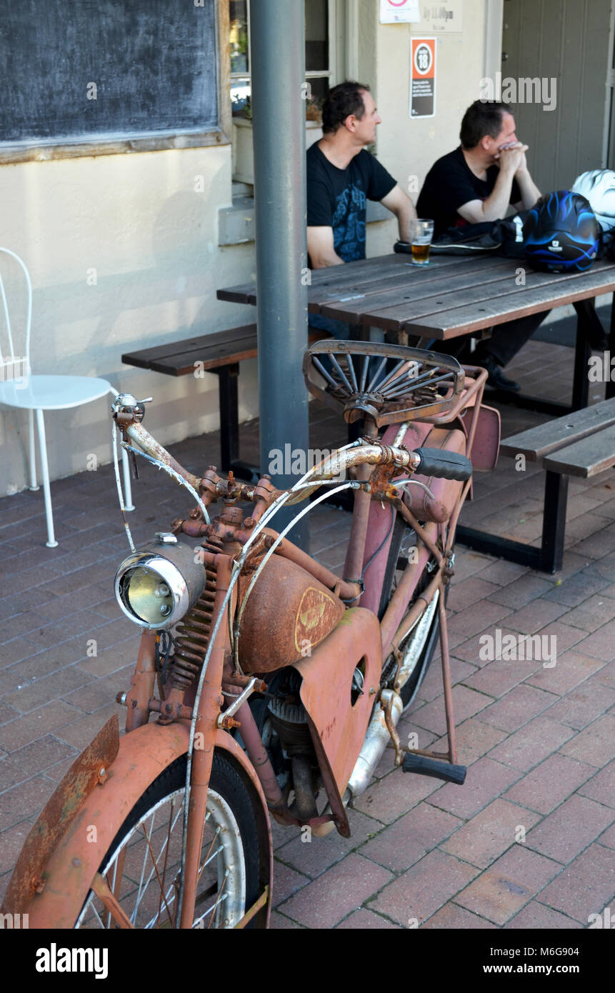 Vintage motorbike and men drinking outside hotel pub with motorbike helmets in Kangaroo Valley NSW Australia Stock Photo