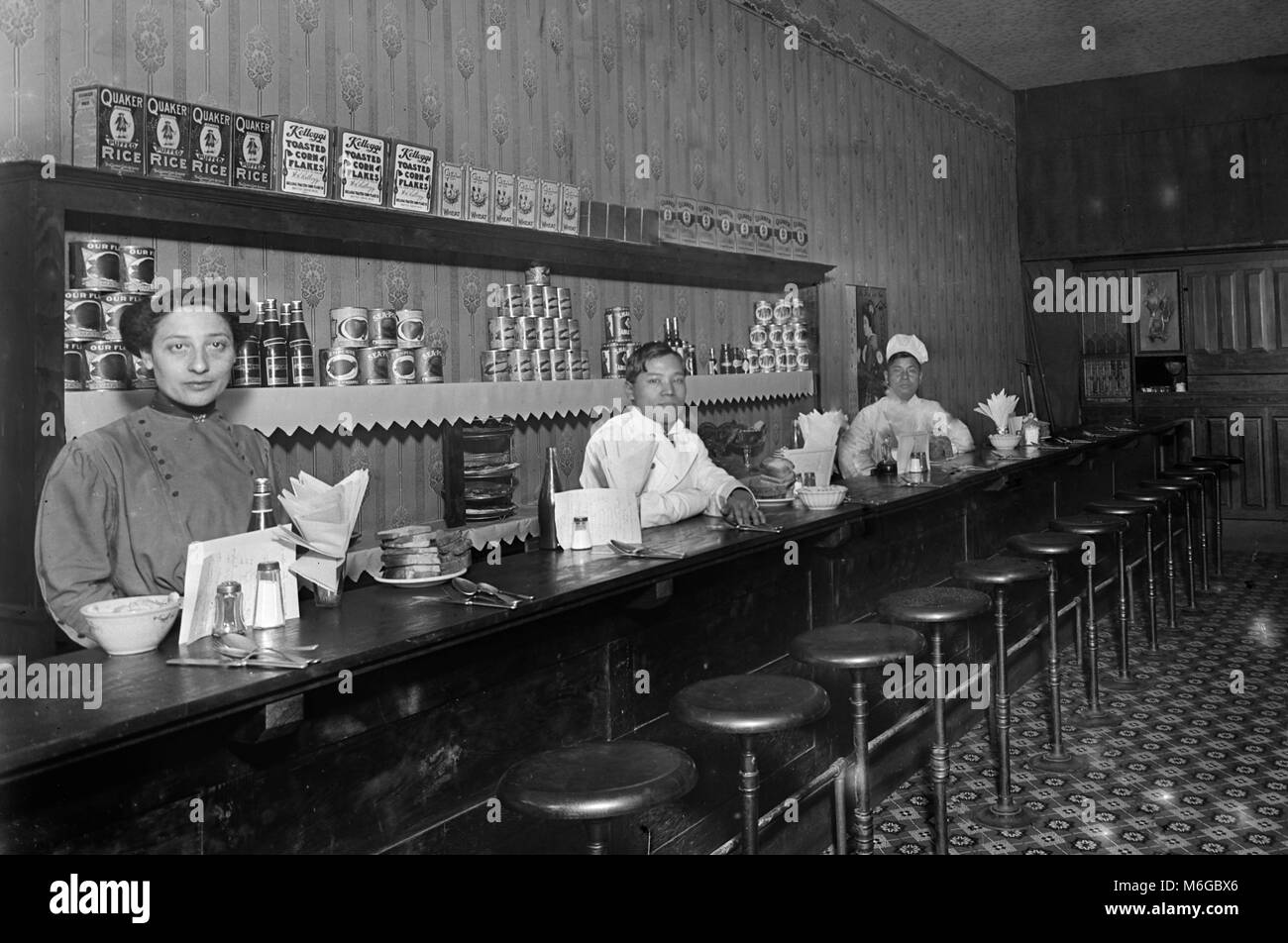 An Asian crew poses behind the counter at a diner in Seattle, Washington, ca. 1912. Stock Photo