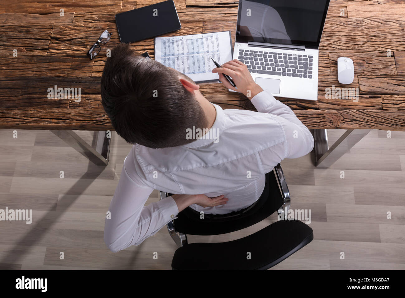 High Angle View Of A Businessman Suffering From Back Pain In Office Stock Photo