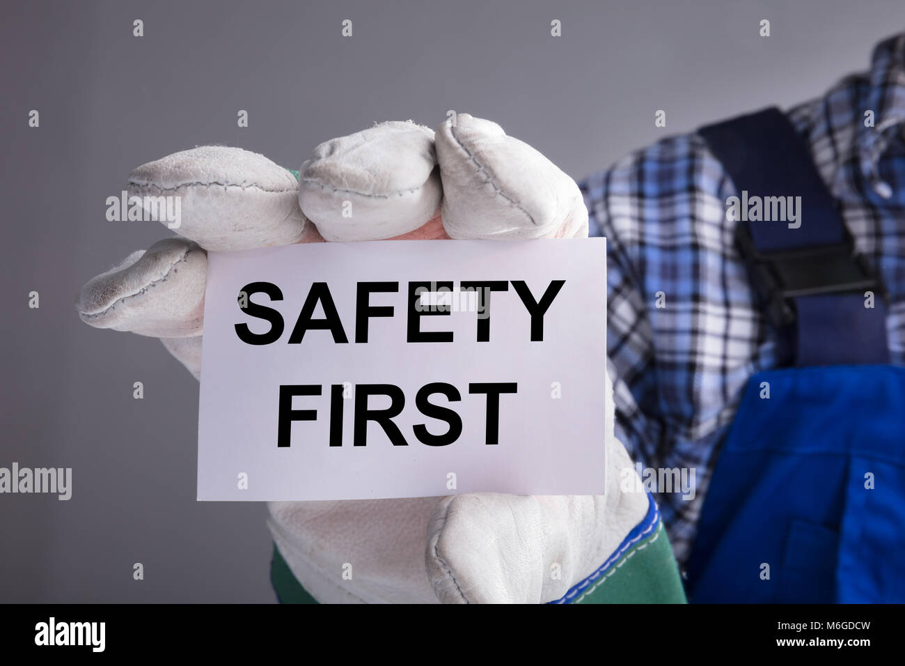 Closeup Of Workman Hands With Gloves Showing Safety First Sign Stock Photo Alamy