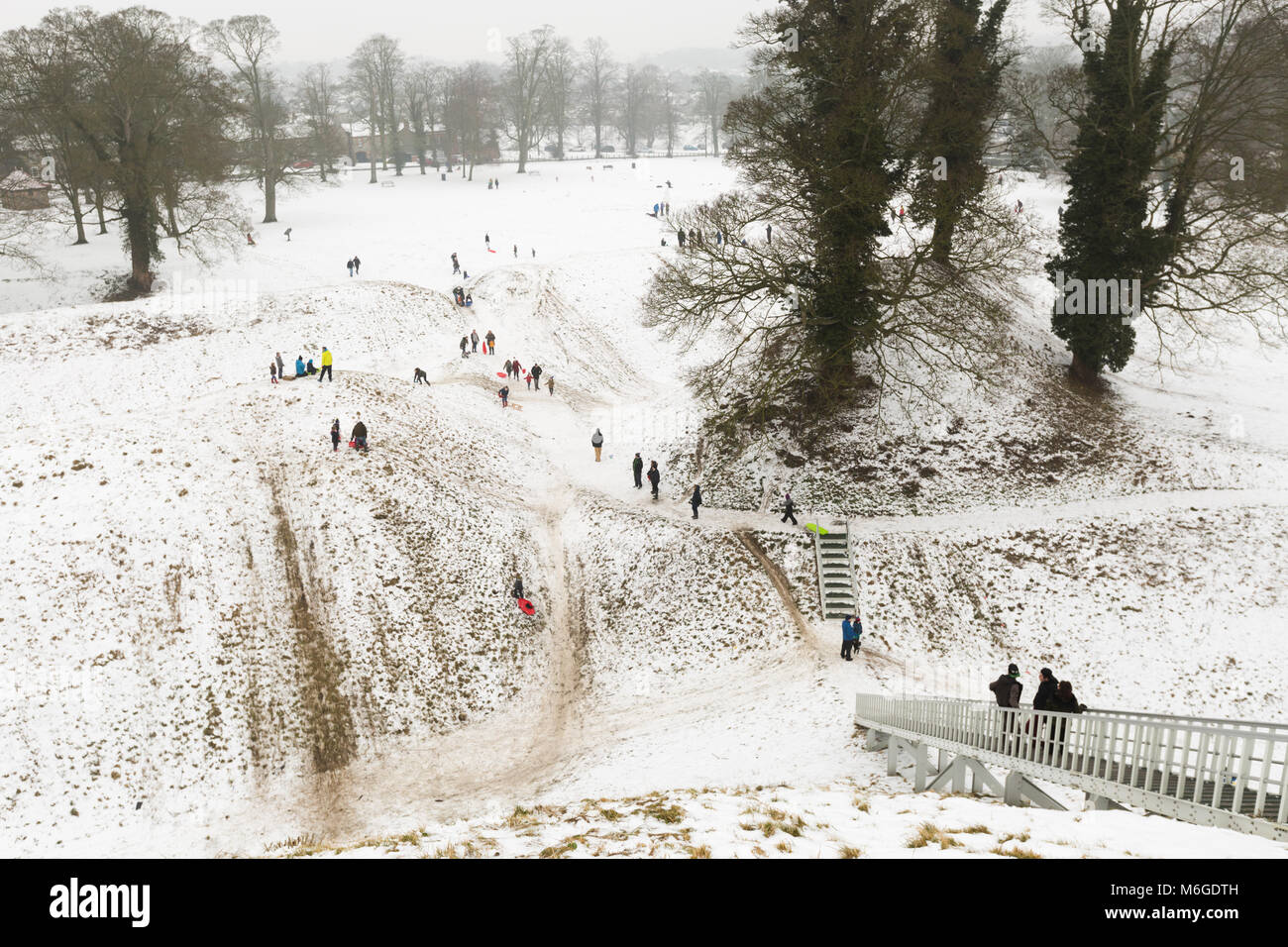 Aerial view from Castle Hill at Thetford, Norfolk of families playing and sledging on snow. Stock Photo