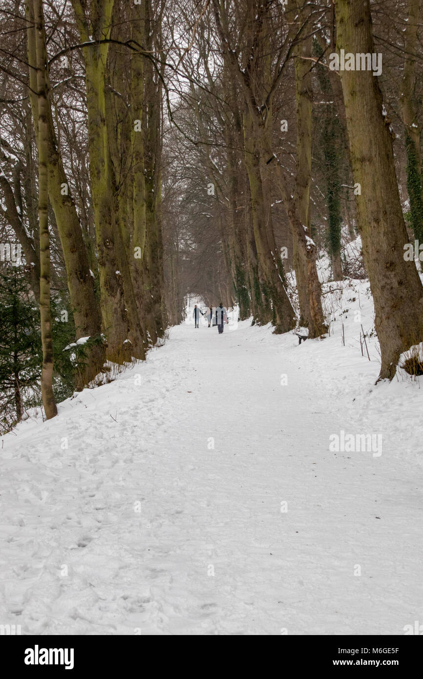 People walking along snowy path beside the River Wear in Durham UK Stock Photo