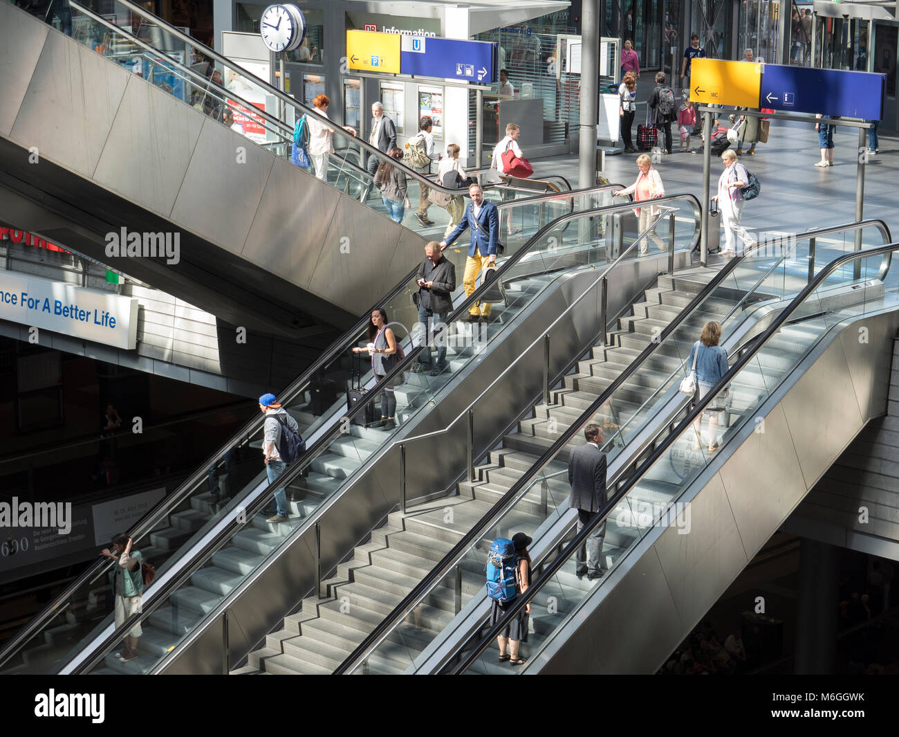 Travellers at Berlin's main railway station Hauptbahnhof taking the escalators to platform level. Berlin Central station is the largest in Europe Stock Photo
