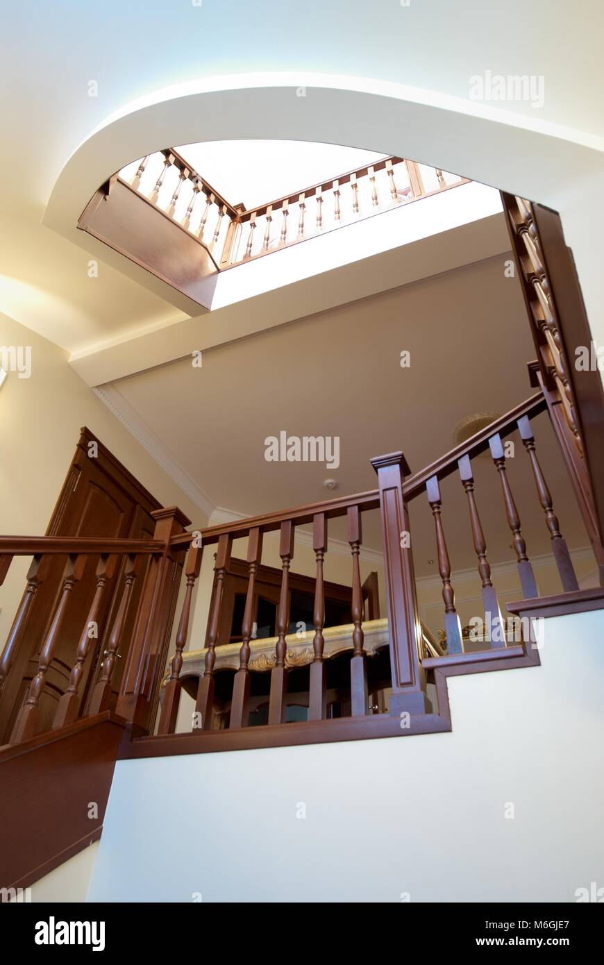 Spiral wooden staircase with balusters pillars and a massive handrail