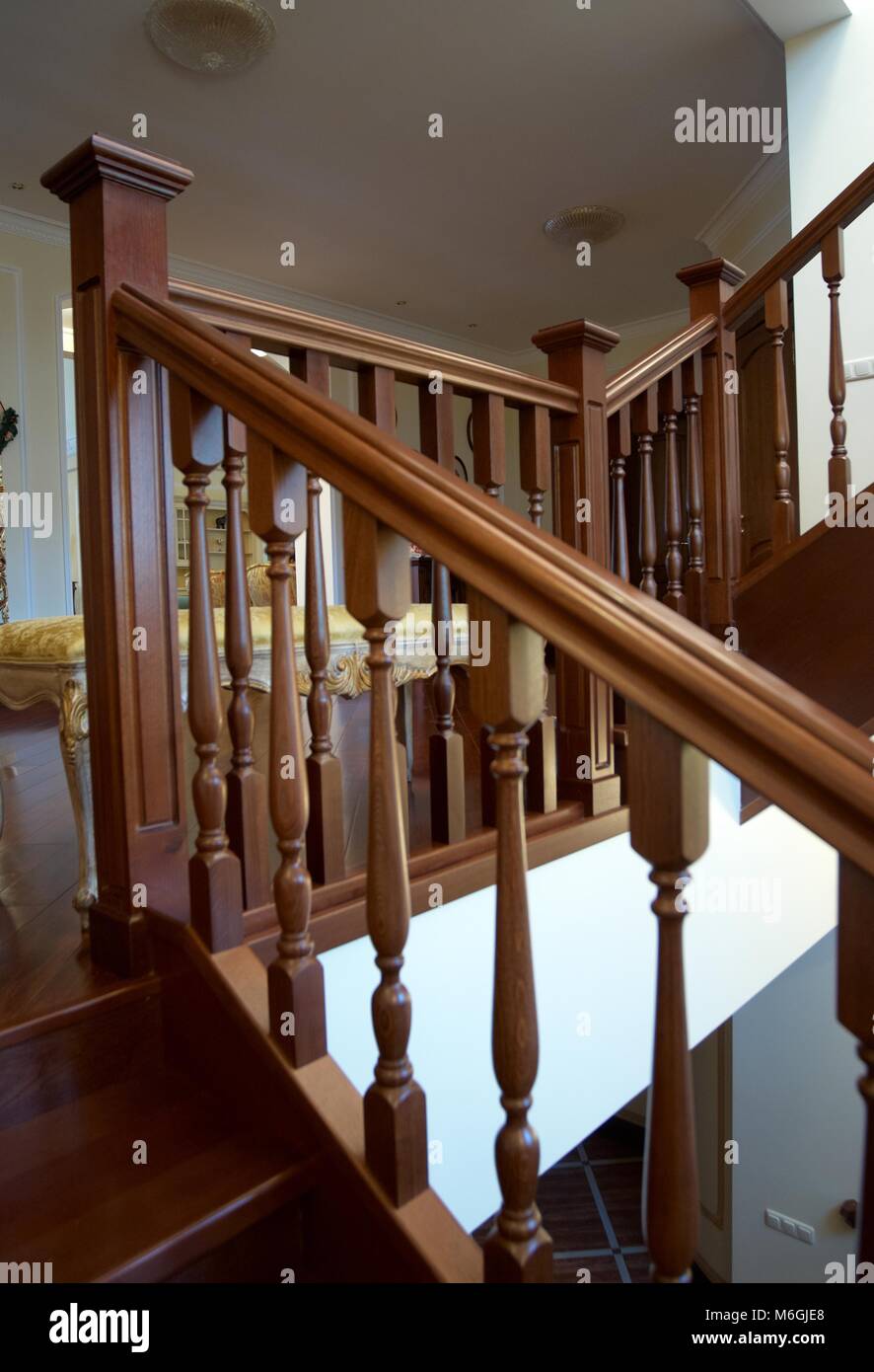 Spiral wooden staircase with balusters pillars and a massive handrail