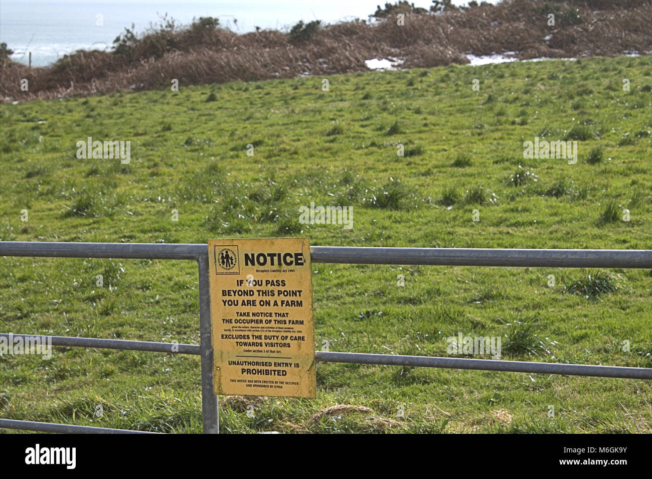 warning notice on a farm gate of entering at your own risk. Stock Photo