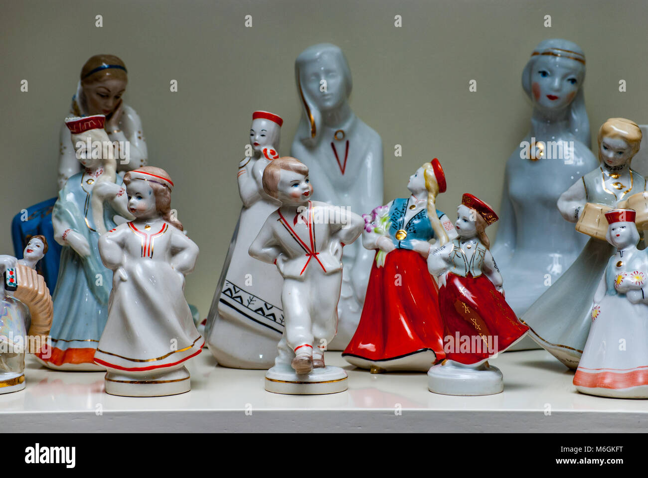 Collection of different colorful vintage porcelain statuettes exhibited