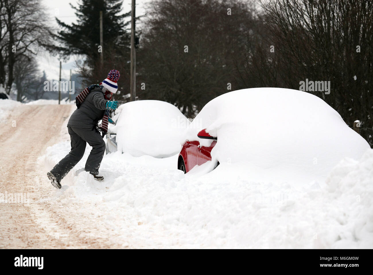 A woman goes to her snow covered car in rural Carron Valley near