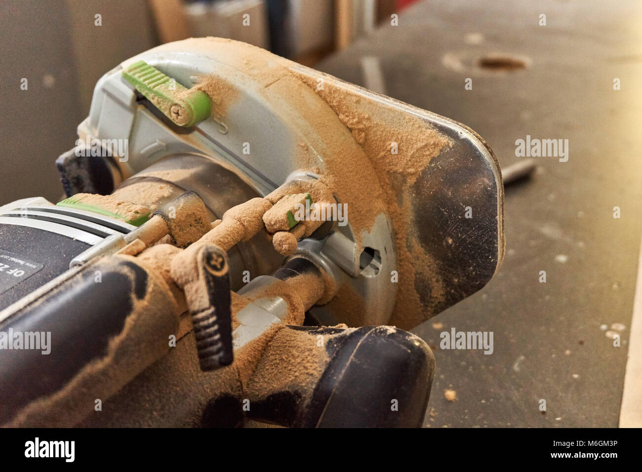 Manual woodworking router shows signs of diligent use, cloaked in a fine layer of workshop dust Stock Photo